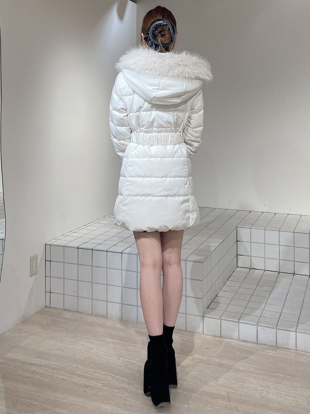 ホワイト系のダウンジャケット/コート、グレー系のワンピース、ブラック系のブーツを着用したレディースの秋コーディネートの4枚目の写真