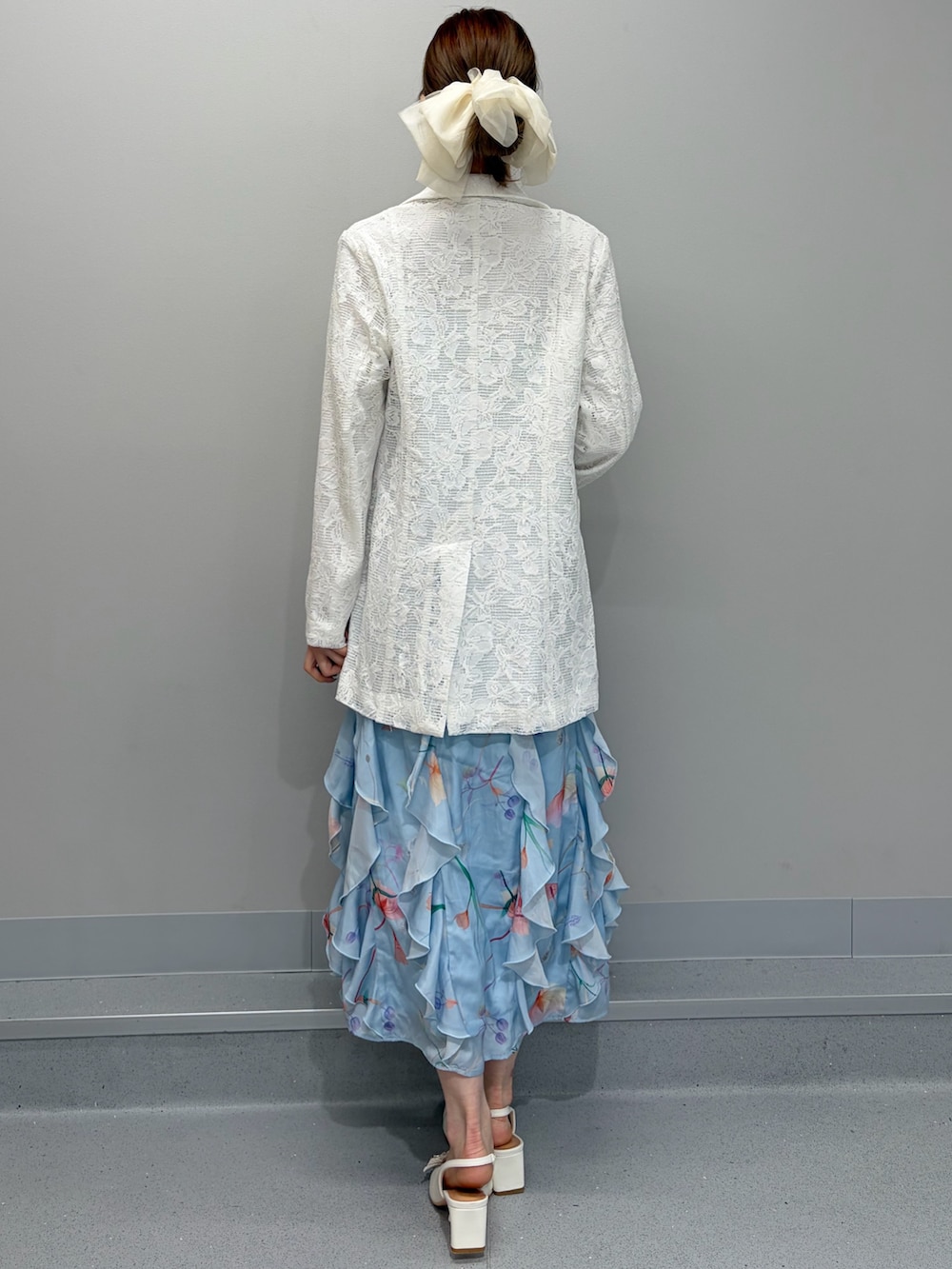 ホワイト系のテーラードジャケット、ブルー系のワンピース、ホワイト系のパンプスを着用したレディースの冬コーディネートの4枚目の写真