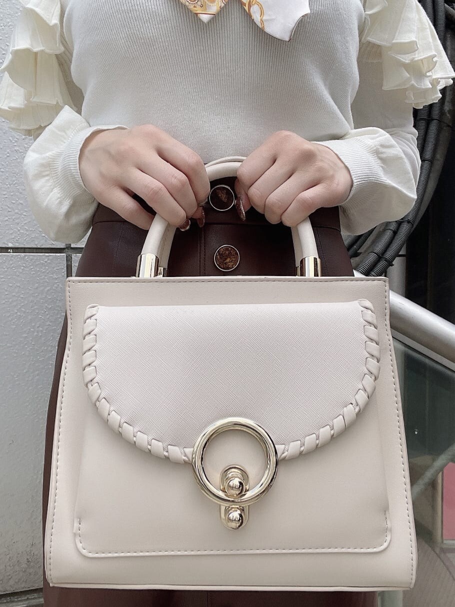 ホワイト系のハンドバッグ、ベージュ系のパンプス、ホワイト系のニット/セーターを着用したレディースの秋コーディネートの10枚目の写真