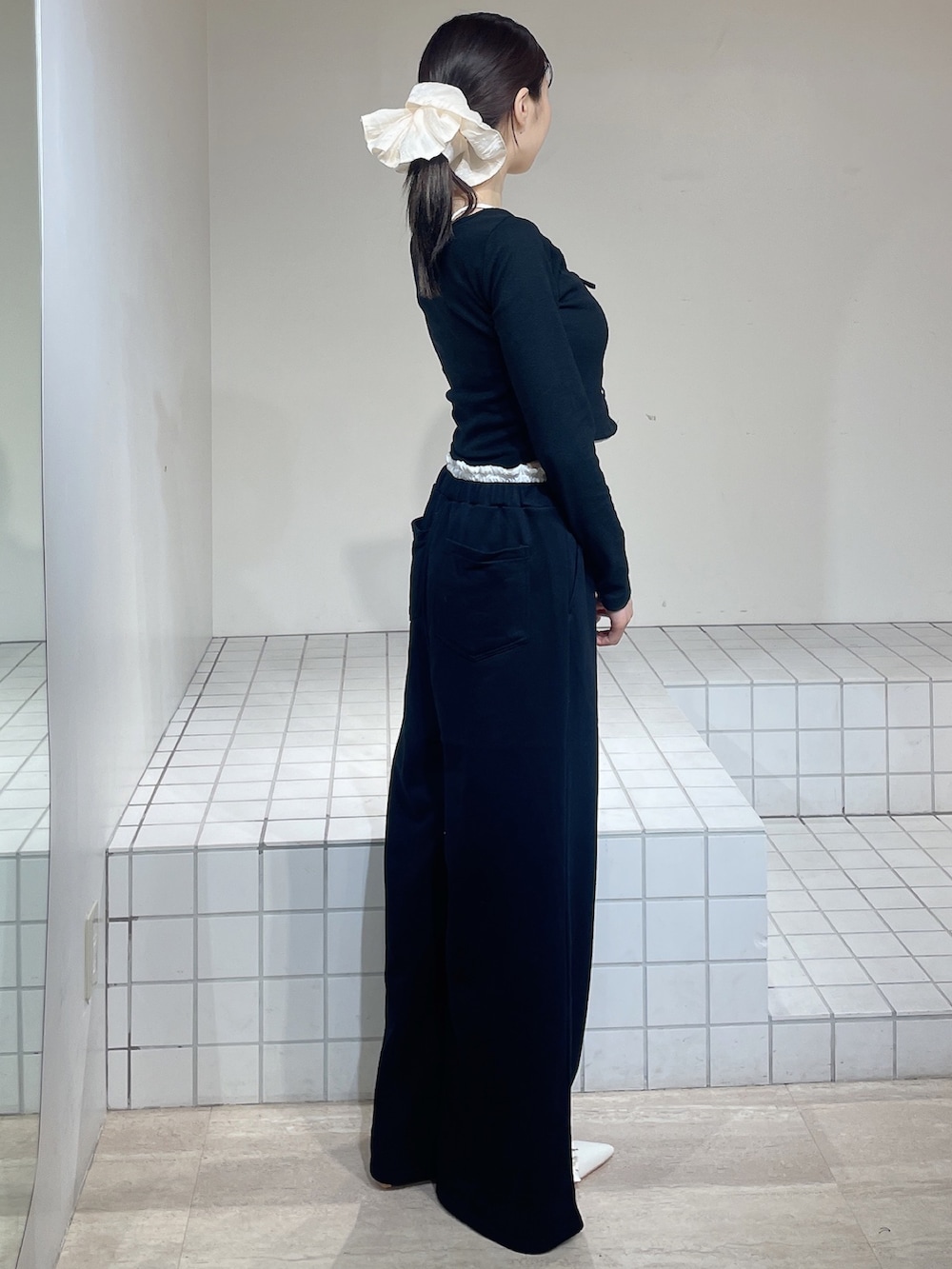 ブラック系のTシャツ/カットソー、ブラック系のその他パンツ、ホワイト系のパンプスを着用したレディースの春コーディネートの2枚目の写真