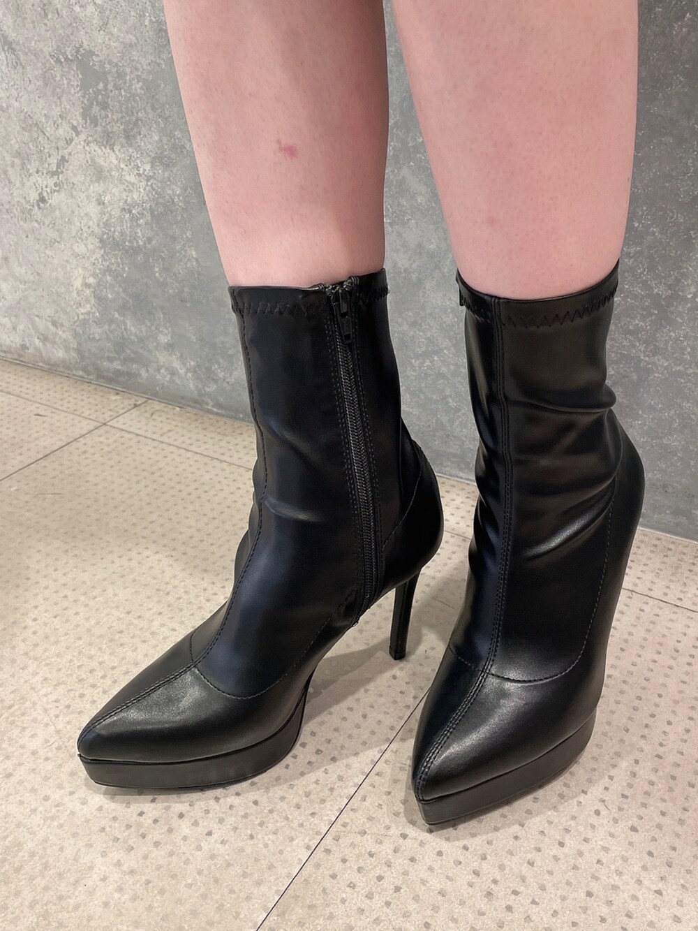 ホワイト系のダウンジャケット/コート、ブラック系のワンピース、ブラック系のブーツを着用したレディースの秋コーディネートの8枚目の写真