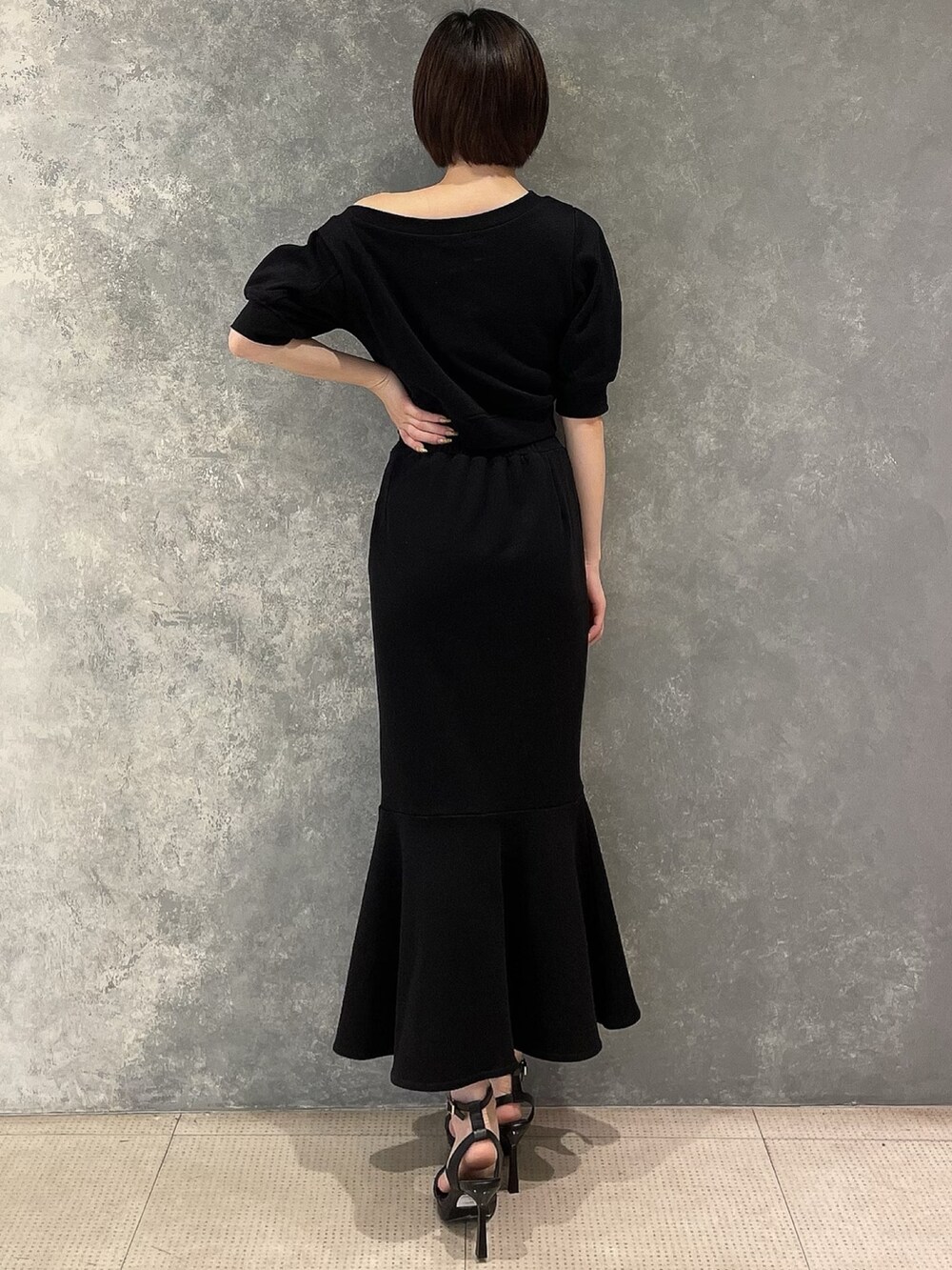 ブラック系のサンダル、ブラック系のスカート、ブラック系のスウェットを着用したレディースの春コーディネートの4枚目の写真