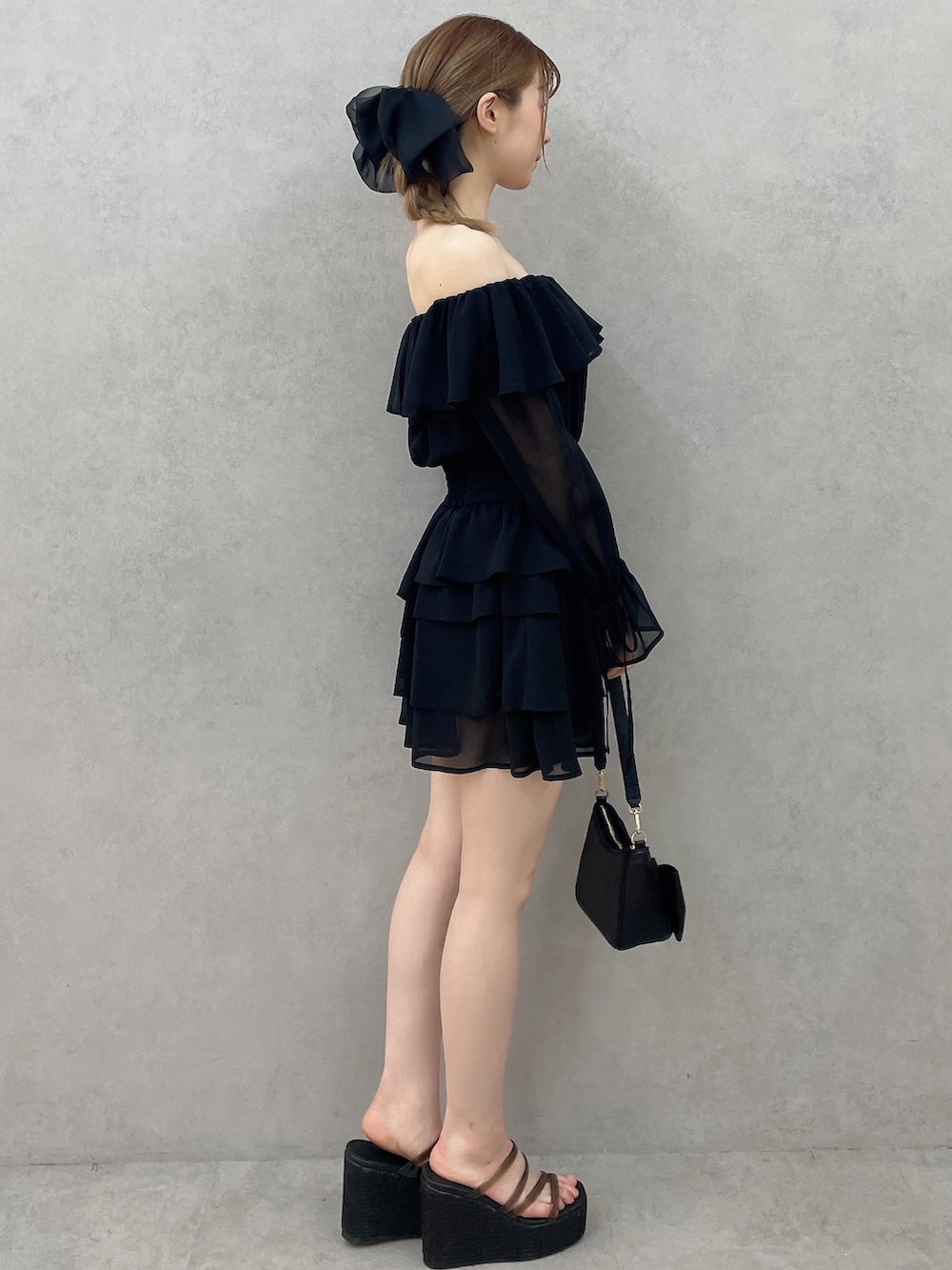 ブラック系のワンピース、ブラック系のハンドバッグ、ブラック系のサンダルを着用したレディースの春コーディネートの3枚目の写真