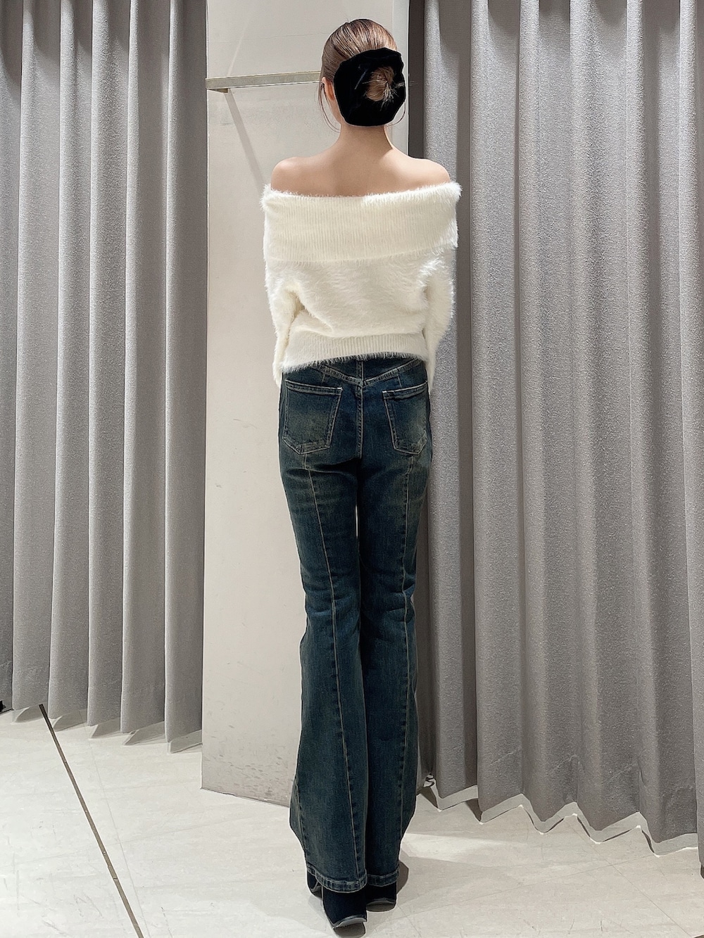 ホワイト系のニット/セーター、ブルー系のデニムパンツ、ブラック系のブーツを着用したレディースの秋コーディネートの4枚目の写真