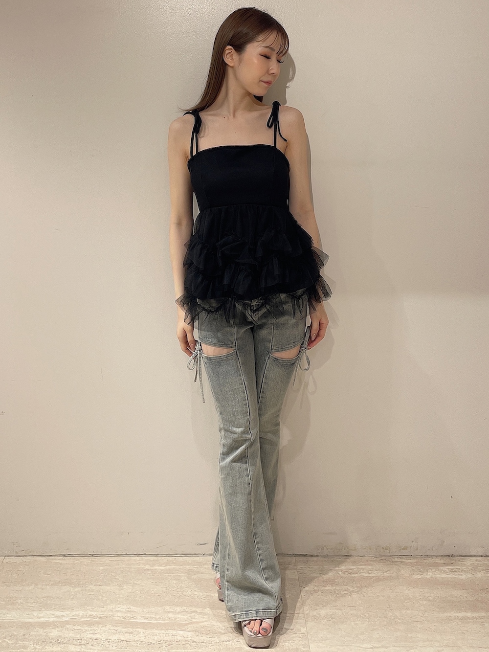 ブラック系のキャミソール、ブルー系のデニムパンツ、ベージュ系のサンダルを着用したレディースの夏コーディネートの2枚目の写真