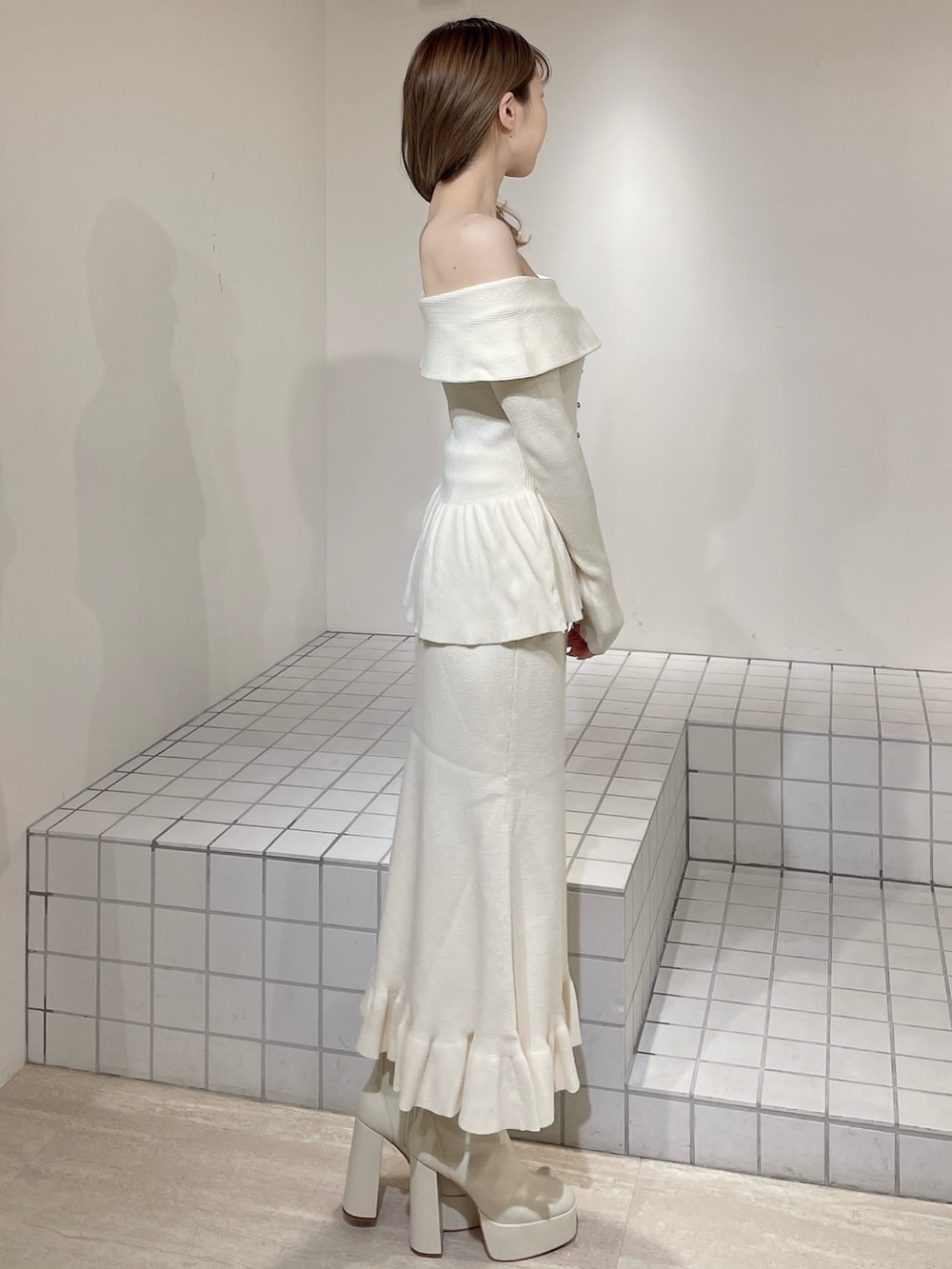 ホワイト系のニット/セーター、ホワイト系のスカート、ホワイト系のブーツを着用したレディースの冬コーディネートの3枚目の写真