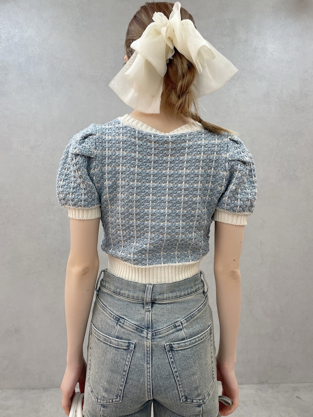 ブルー系のニット/セーター、ホワイト系のハンドバッグ、ホワイト系のサンダルを着用したレディースの春コーディネートの5枚目の写真