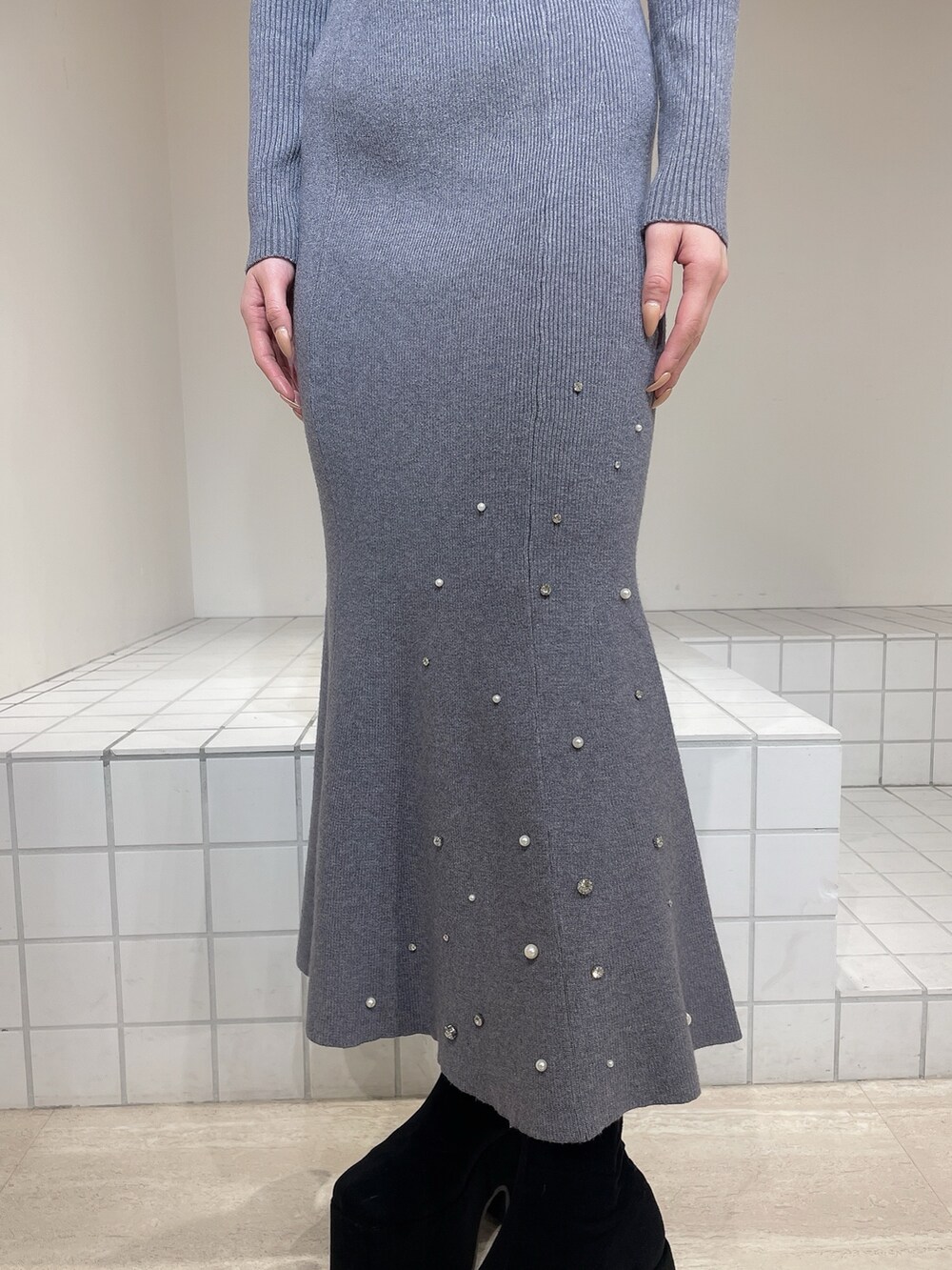 グレー系のワンピース、ブラック系のブーツ、ブラック系のバレッタ/ヘアクリップを着用したレディースの冬コーディネートの8枚目の写真