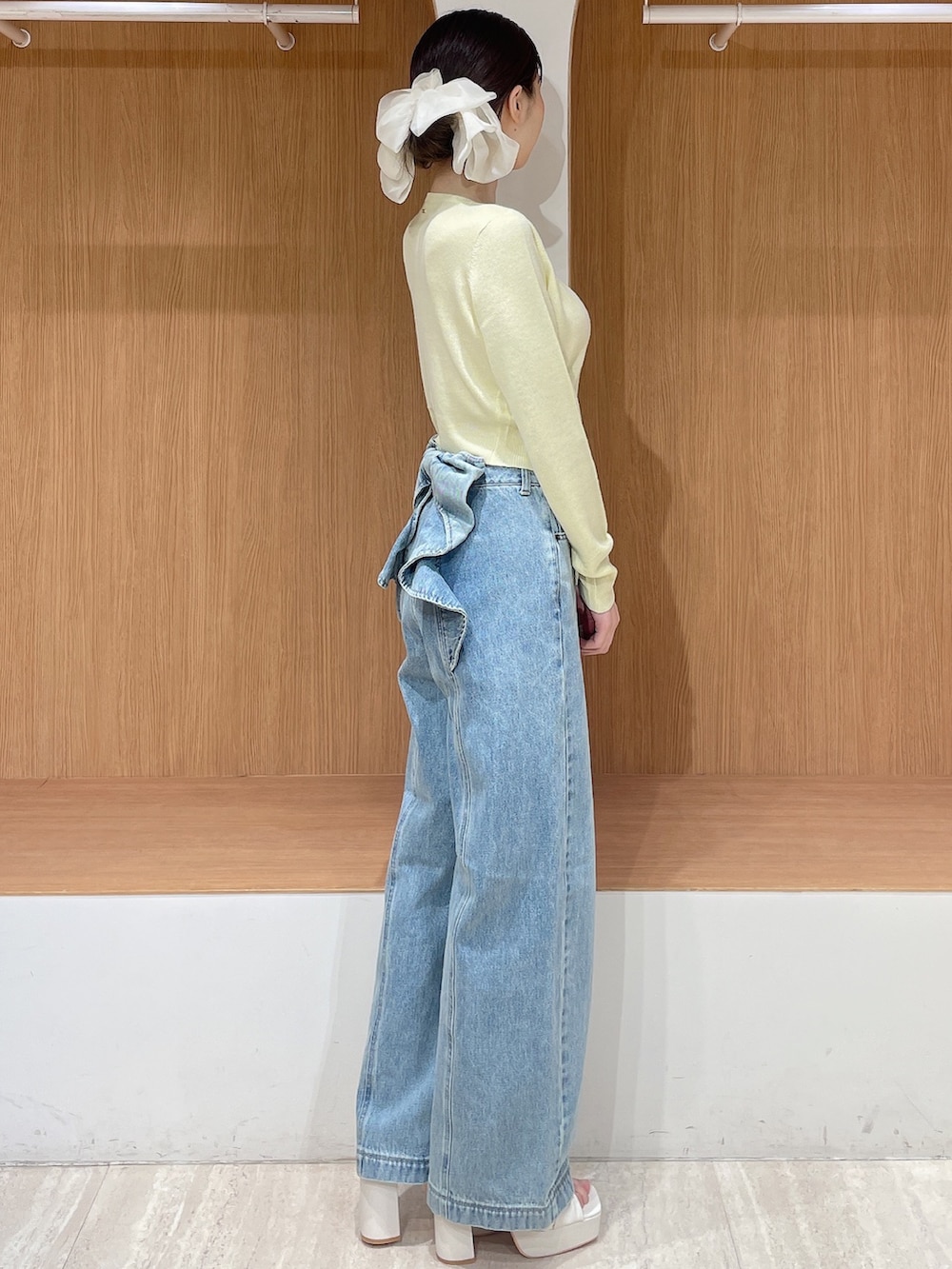 ホワイト系のテーラードジャケット、イエロー系のカーディガン/ボレロ、ブルー系のデニムパンツを着用したレディースの春コーディネートの5枚目の写真