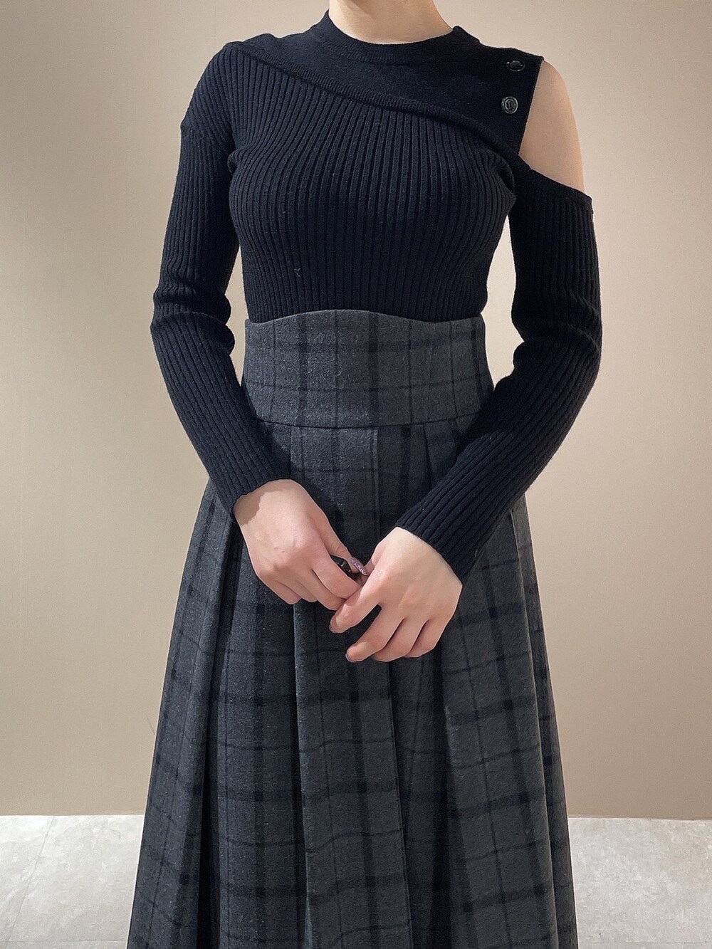 ブラック系のニット/セーター、ブラック系のスカート、ブラック系のブーツを着用したレディースの秋コーディネートの6枚目の写真