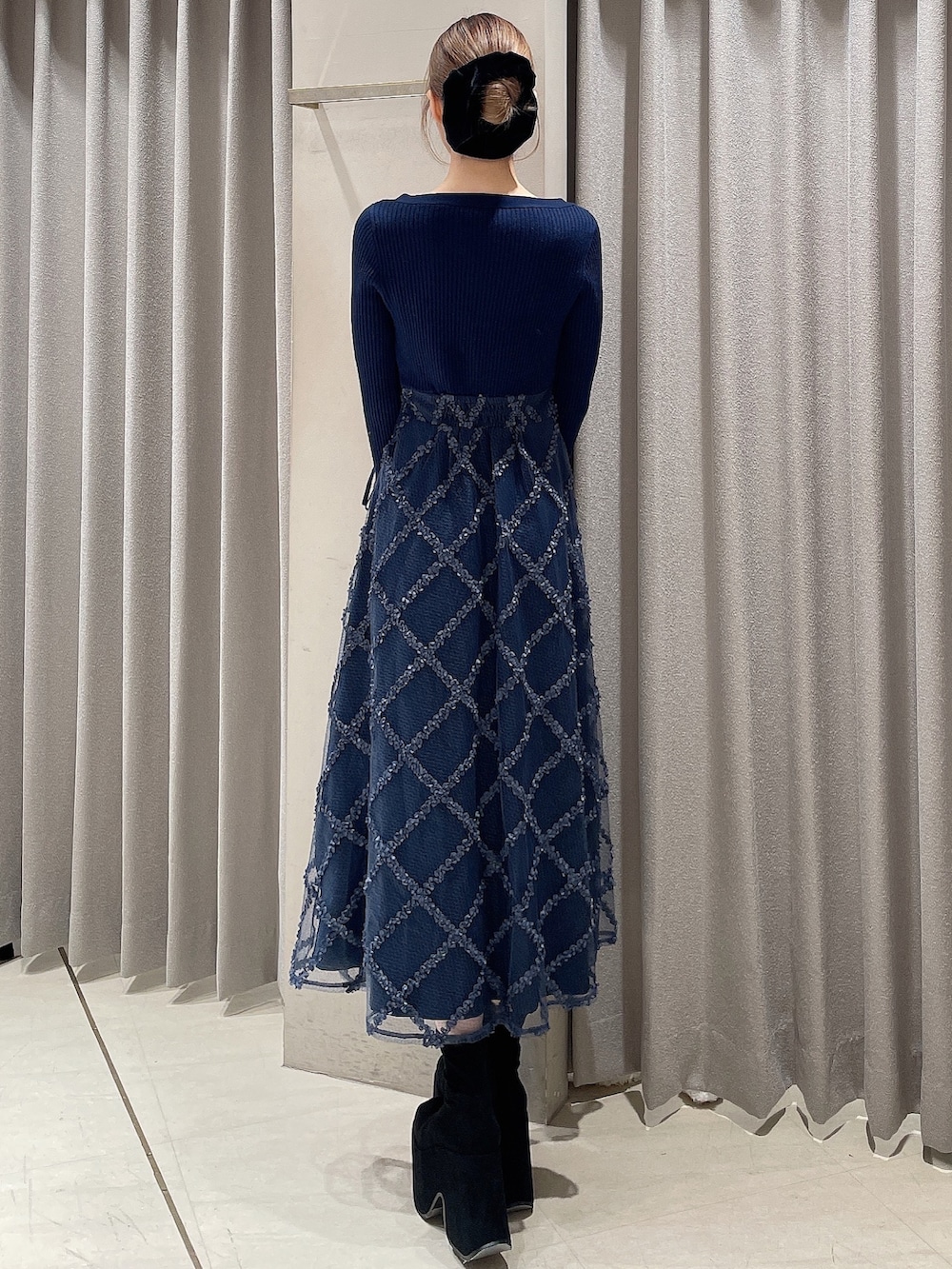 ブルー系のワンピース、ブラック系のブーツ、ブラック系のシュシュを着用したレディースの秋コーディネートの5枚目の写真