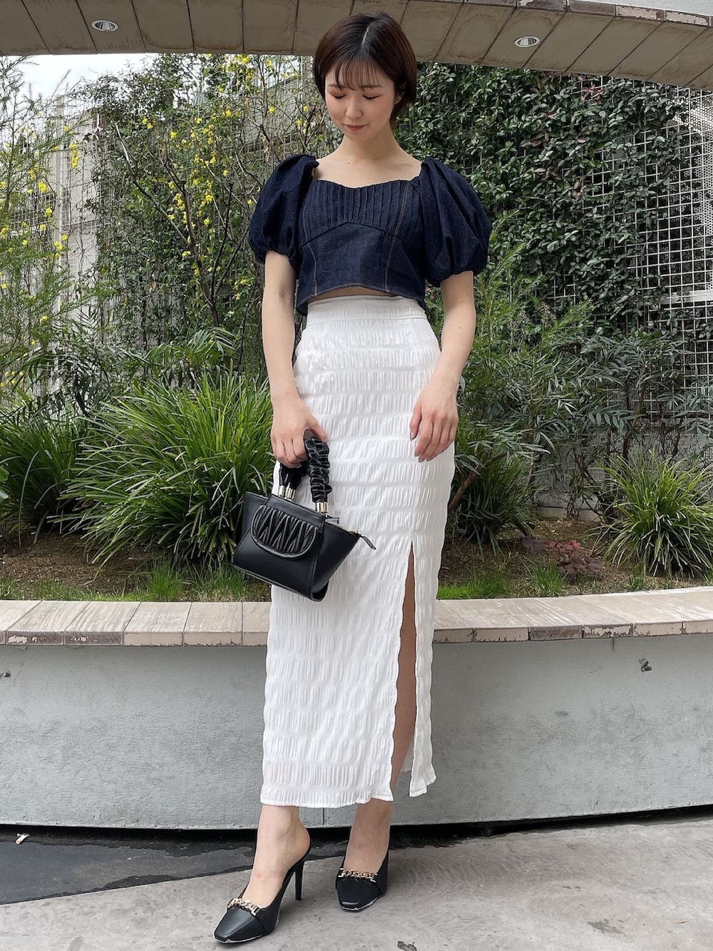 ブルー系のシャツ/ブラウス、ブラック系のハンドバッグ、ブラック系のサンダルを着用したレディースの春コーディネートの2枚目の写真