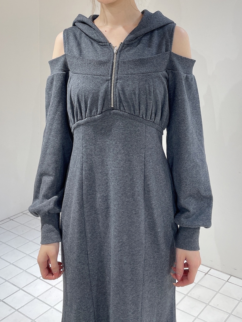 グレー系のワンピース、ブラック系のブーツ、グレー系のシュシュを着用したレディースの秋コーディネートの4枚目の写真