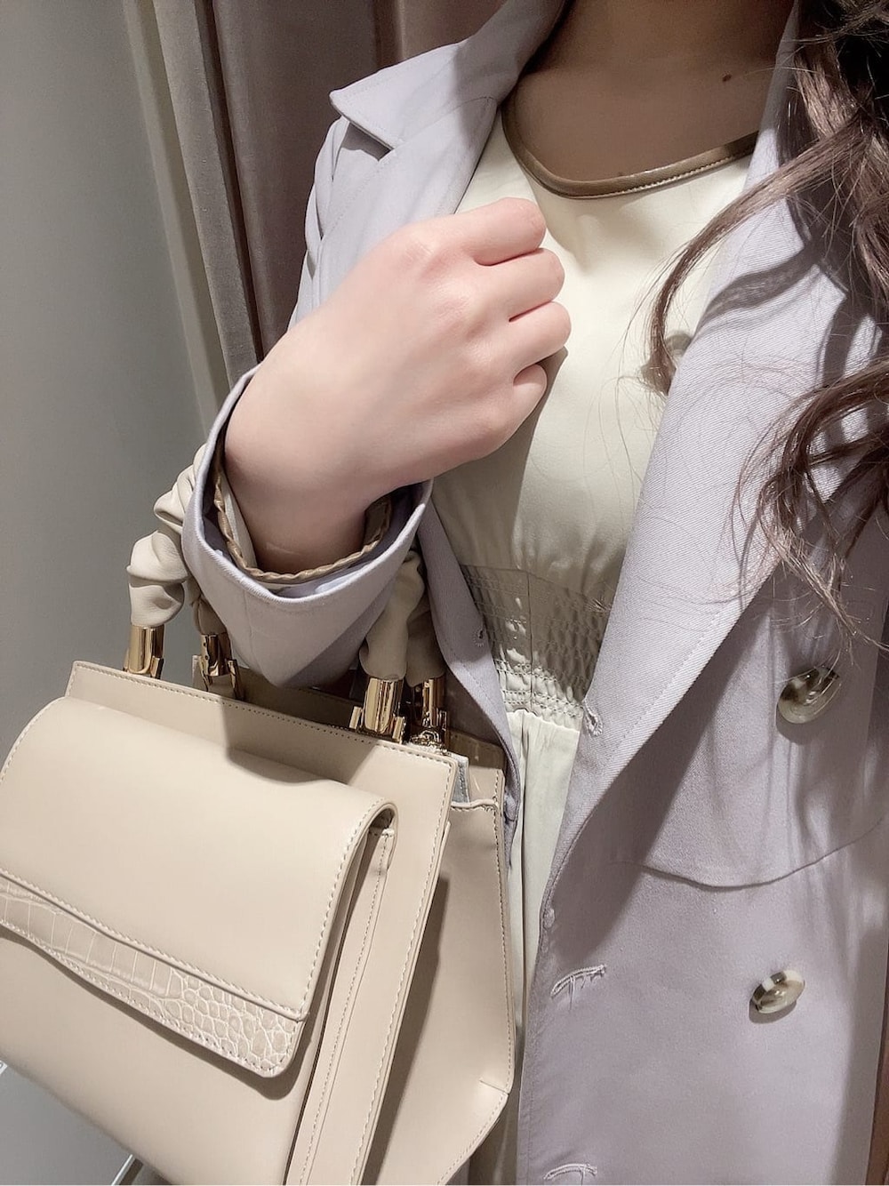 ベージュ系のワンピース、パープル系のトレンチコート、ブラウン系のブーツを着用したレディースの冬コーディネートの8枚目の写真