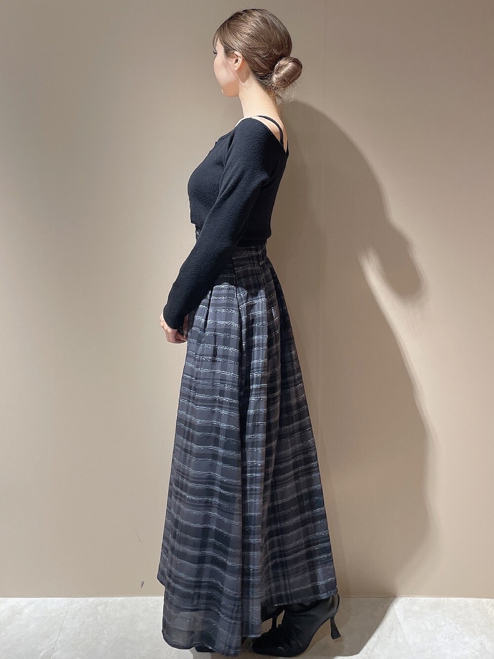 ブラック系のブーツ、ブラック系のワンピースを着用したレディースの秋コーディネートの2枚目の写真