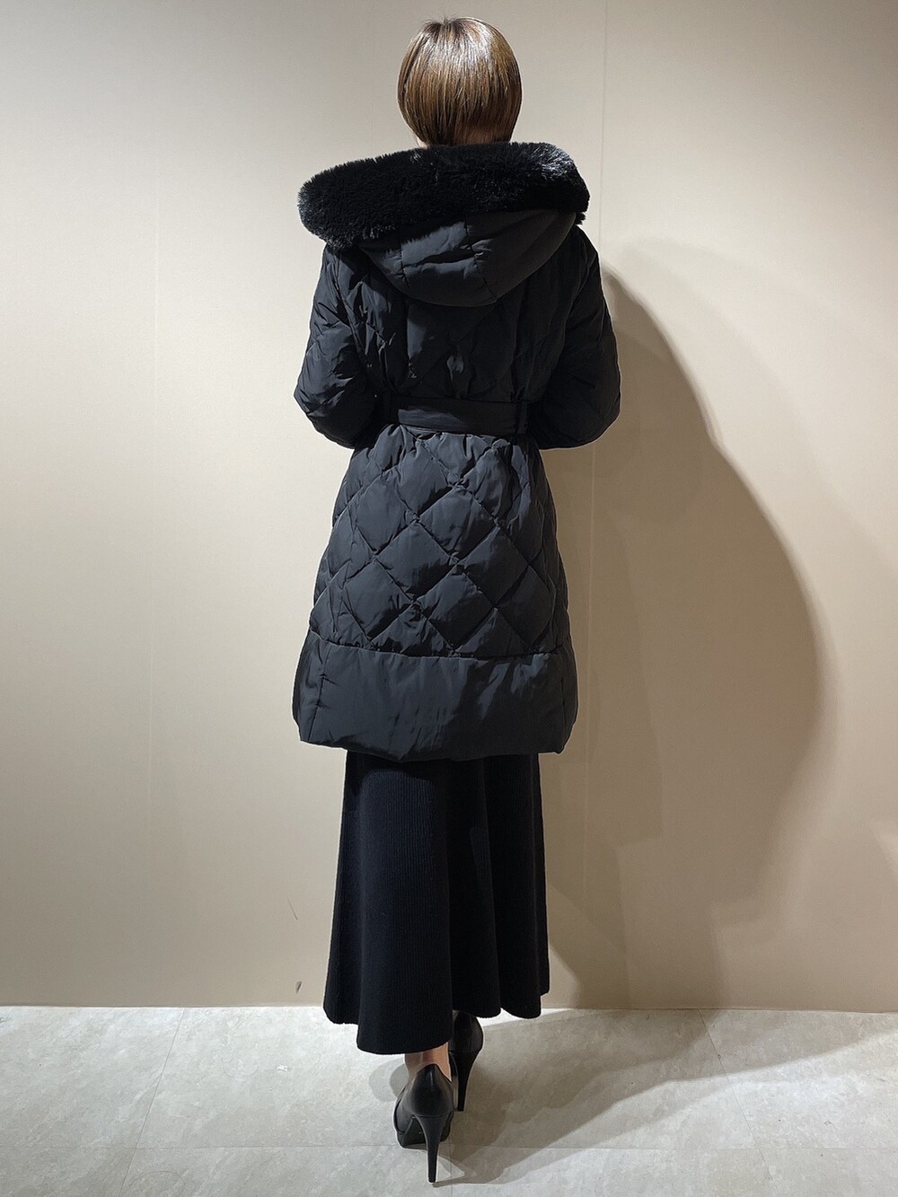 ブラック系のダウンジャケット/コート、ブラック系のワンピース、ブラック系のパンプスを着用したレディースの秋コーディネートの6枚目の写真