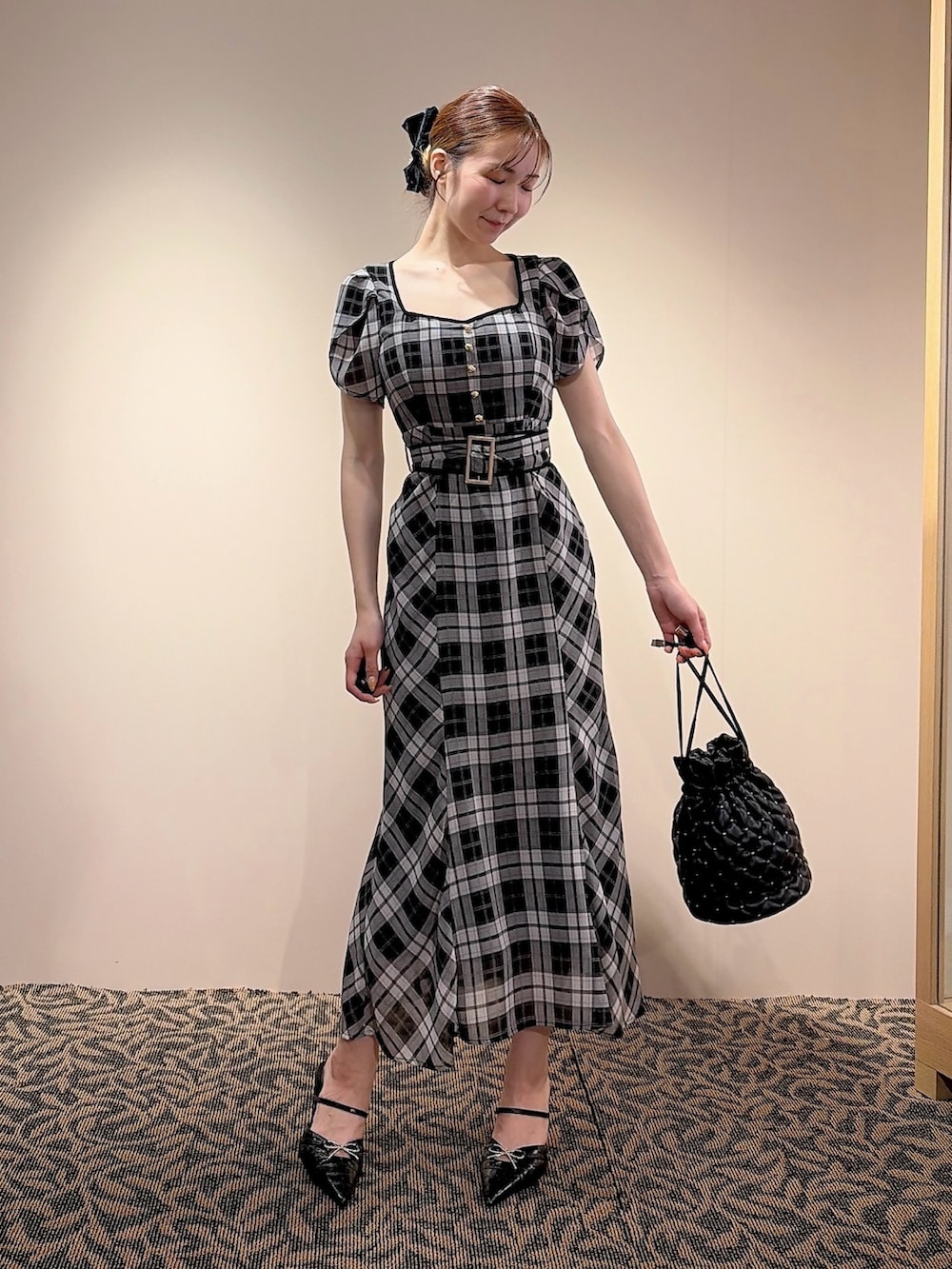 ブラック系のワンピース、ブラック系のハンドバッグ、ブラック系のバレッタ/ヘアクリップを着用したレディースの夏コーディネートの2枚目の写真