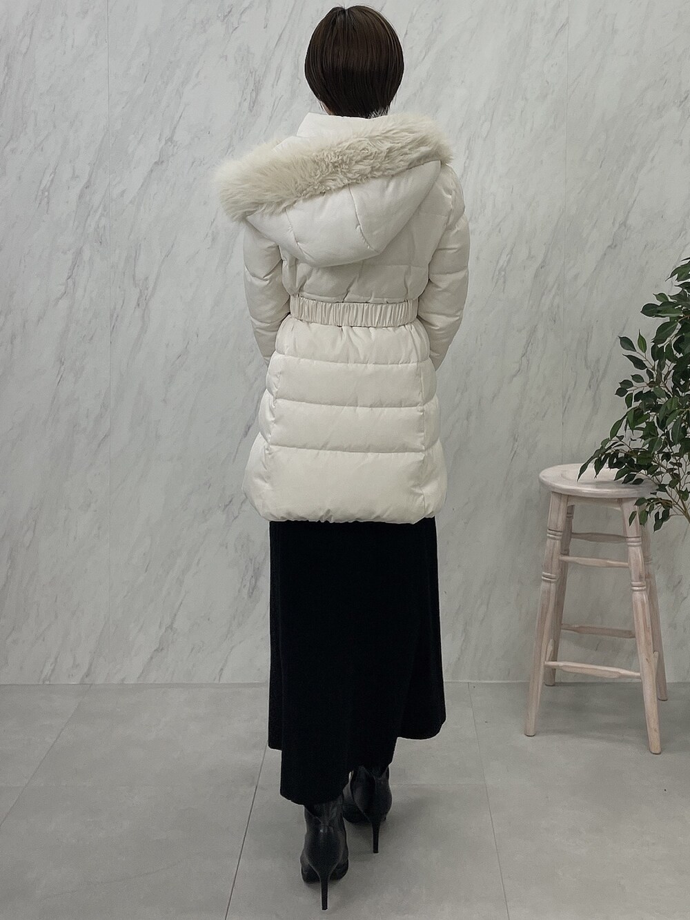 ブラック系のブーツ、ブラック系のワンピース、ホワイト系のダウンジャケット/コートを着用したレディースの夏コーディネートの3枚目の写真