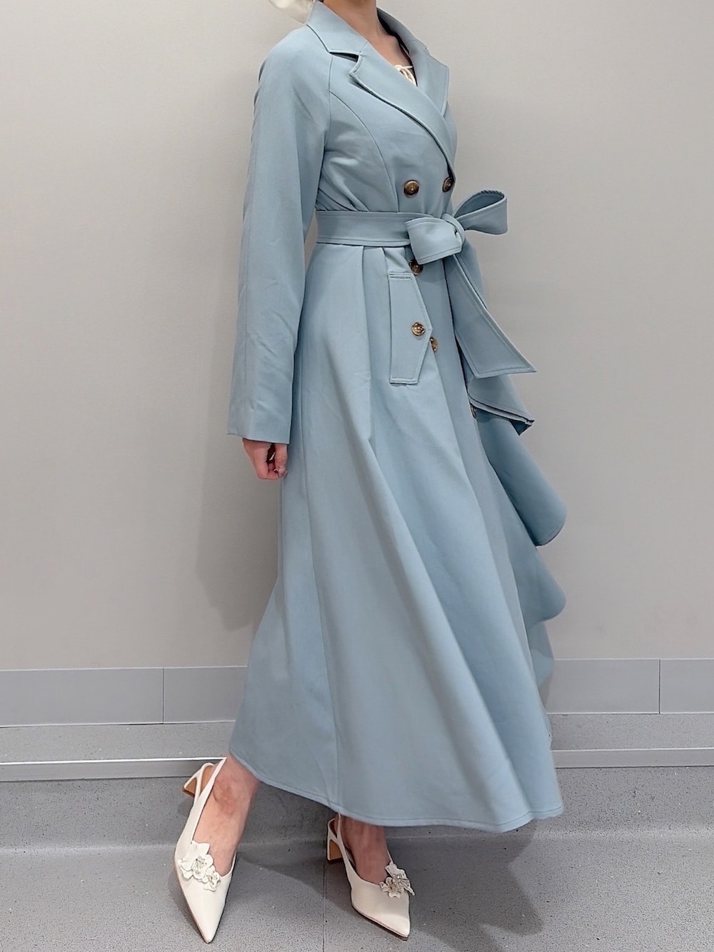 ブルー系のトレンチコート、ホワイト系のパンプス、ホワイト系のバレッタ/ヘアクリップを着用したレディースの冬コーディネートの4枚目の写真