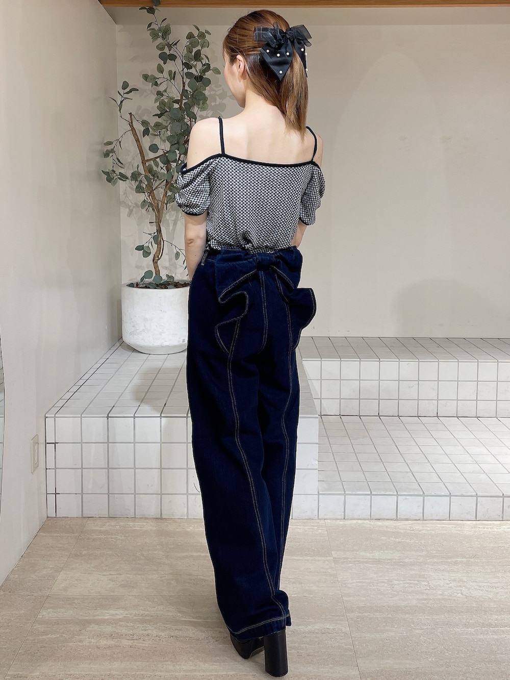 ブラック系のサンダル、ブルー系のデニムパンツ、ブラック系のTシャツ/カットソーを着用したレディースの夏コーディネートの3枚目の写真