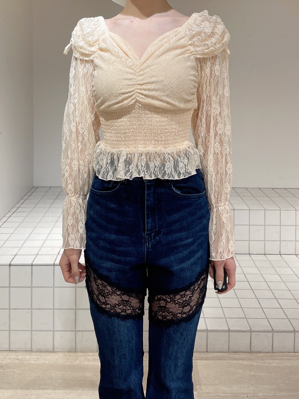 オレンジ系のシャツ/ブラウス、ブルー系のデニムパンツ、ホワイト系のブーツを着用したレディースの春コーディネートの5枚目の写真