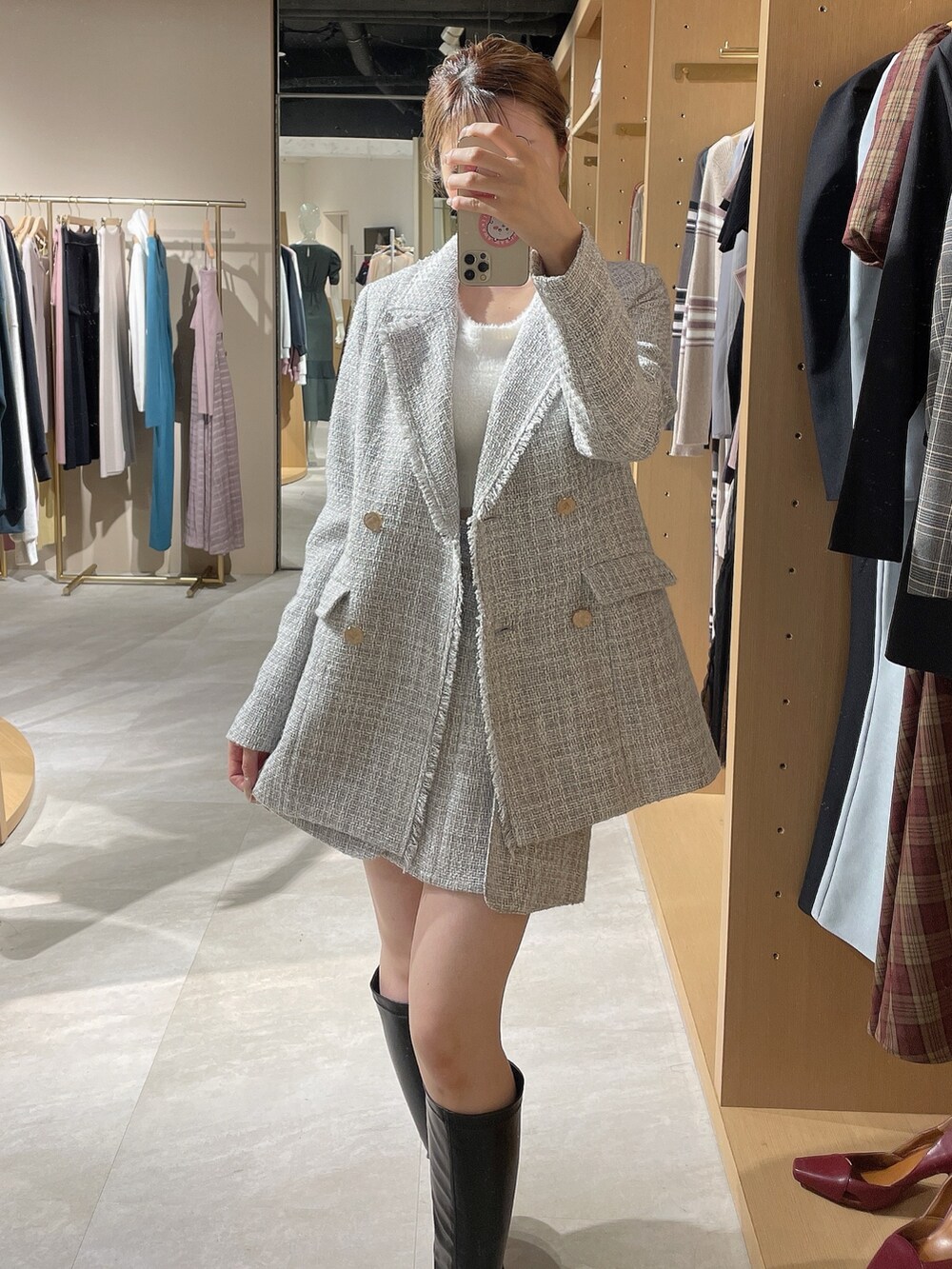 グレー系のテーラードジャケット、グレー系のスカート、ホワイト系のニット/セーターを着用したレディースの秋コーディネートの8枚目の写真