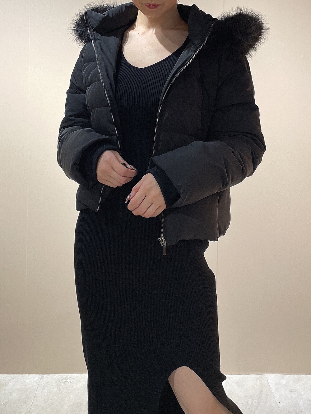 ブラック系のワンピース、ブラック系のダウンジャケット/コート、ブラック系のブーツを着用したレディースの秋コーディネートの7枚目の写真