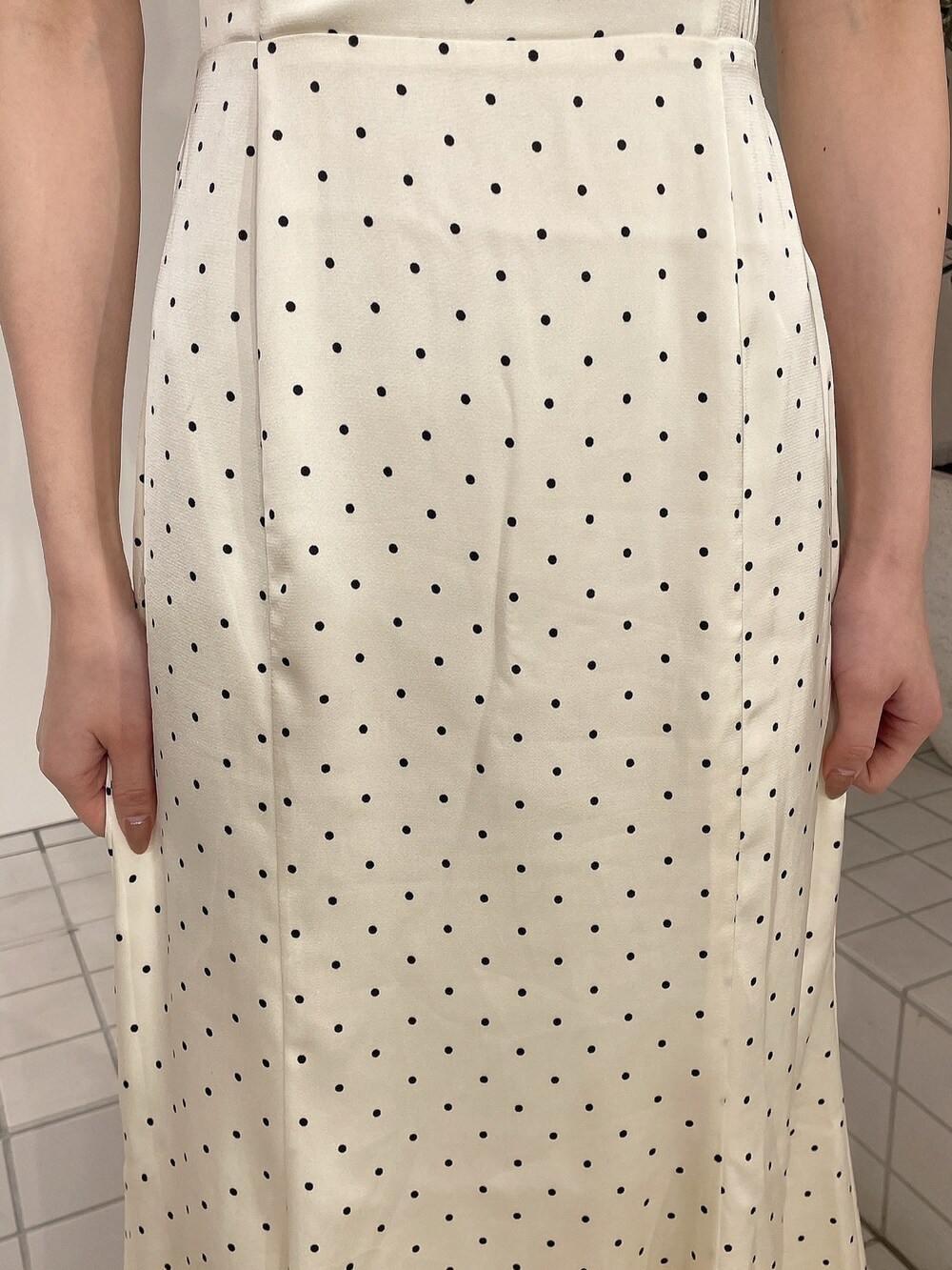 ホワイト系のワンピース、ベージュ系のサンダル、ベージュ系のシュシュを着用したレディースの春コーディネートの6枚目の写真