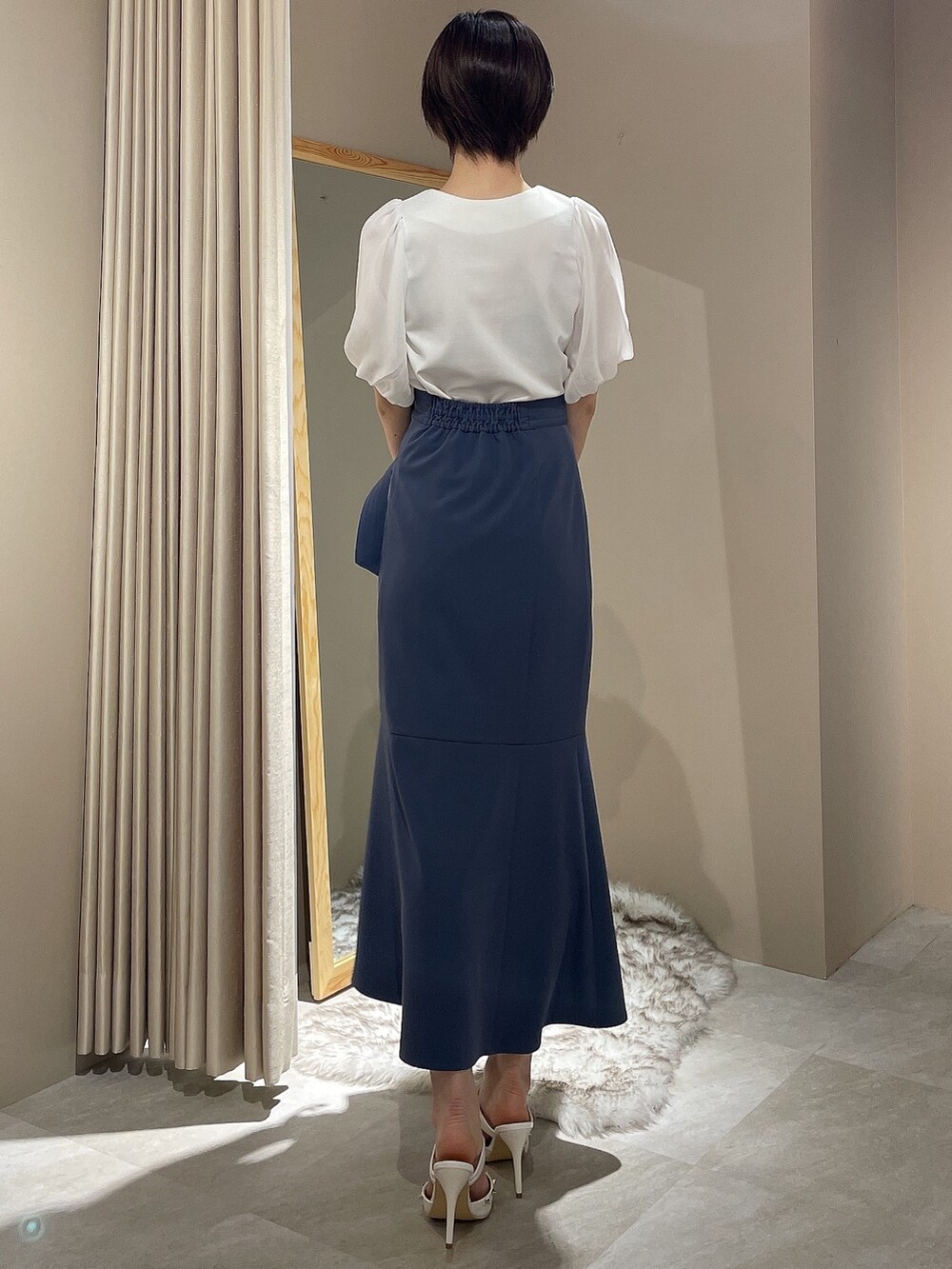 ホワイト系のハンドバッグ、ホワイト系のパンプス、ブルー系のスカートを着用したレディースの春コーディネートの4枚目の写真