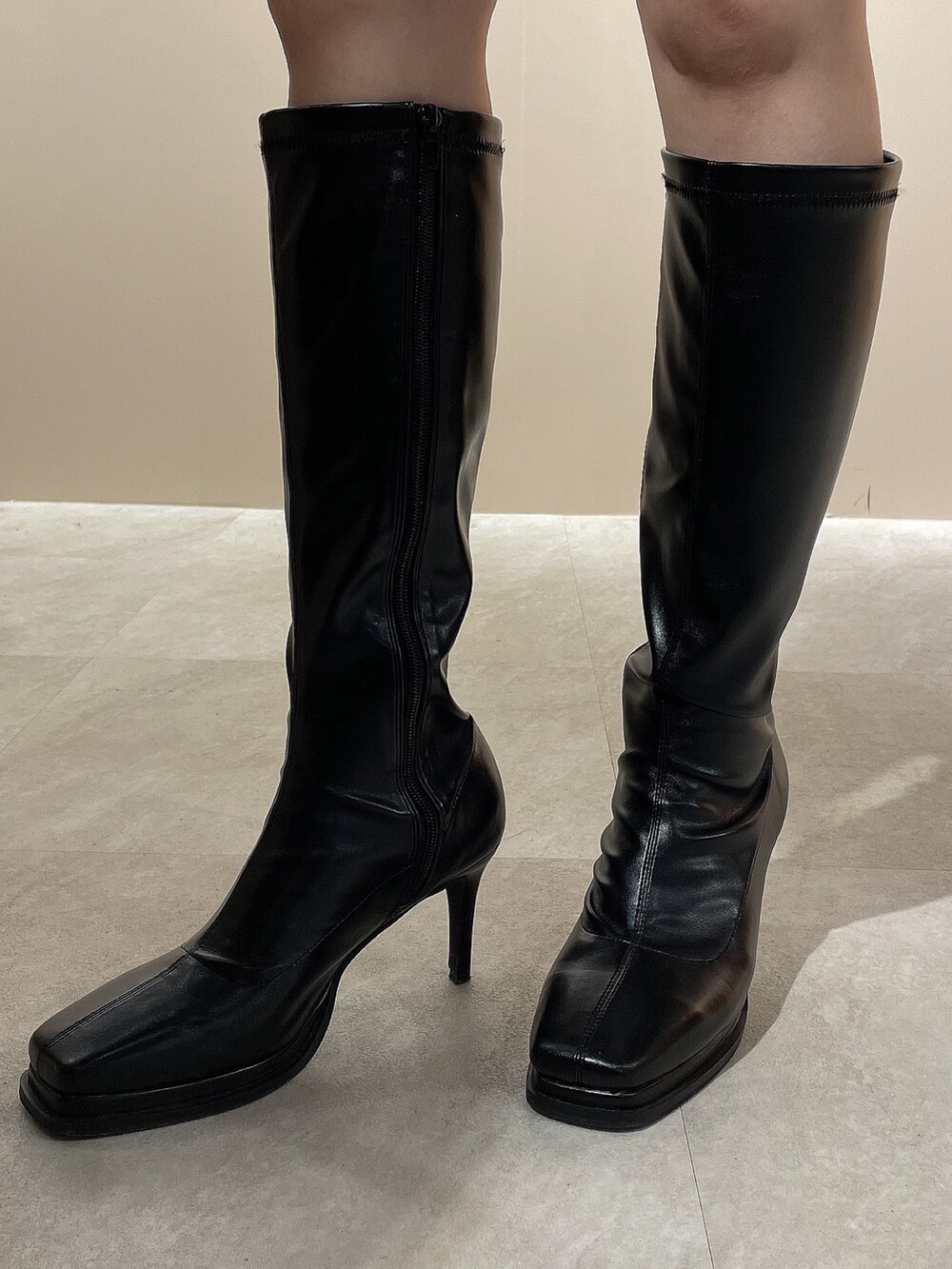 ブラック系のワンピース、ブラック系のダウンジャケット/コート、ブラック系のブーツを着用したレディースの秋コーディネートの9枚目の写真