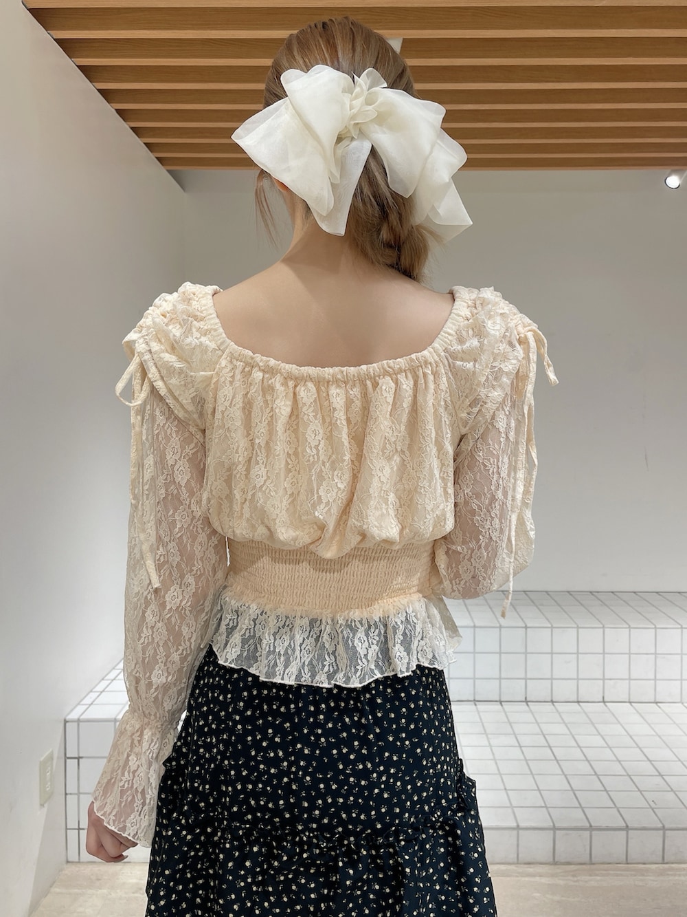 オレンジ系のシャツ/ブラウス、ブラック系のスカート、ホワイト系のパンプスを着用したレディースの春コーディネートの8枚目の写真