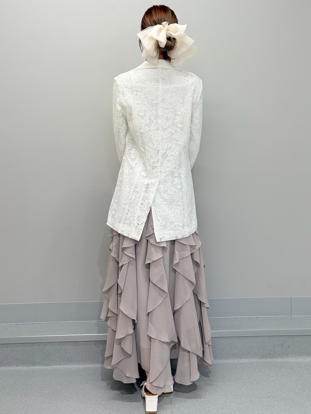 ホワイト系のテーラードジャケット、ホワイト系のシャツ/ブラウス、ベージュ系のスカートを着用したレディースの冬コーディネートの3枚目の写真