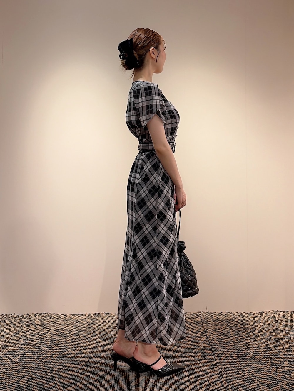 ブラック系のワンピース、ブラック系のハンドバッグ、ブラック系のバレッタ/ヘアクリップを着用したレディースの夏コーディネートの3枚目の写真