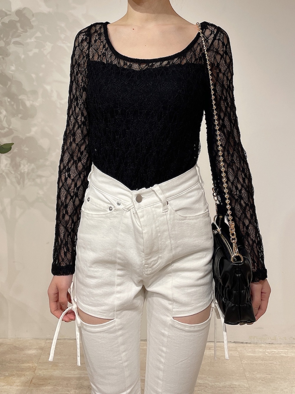 ブラック系のライダースジャケット、ホワイト系のデニムパンツ、ブラック系のブーツを着用したレディースの春コーディネートの8枚目の写真