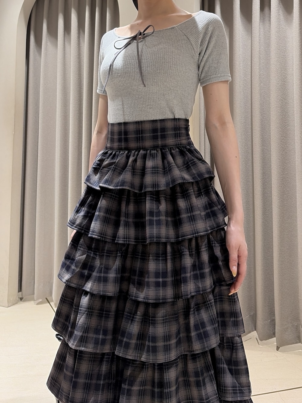 グレー系のTシャツ/カットソー、グレー系のスカート、ブラック系のパンプスを着用したレディースの夏コーディネートの6枚目の写真