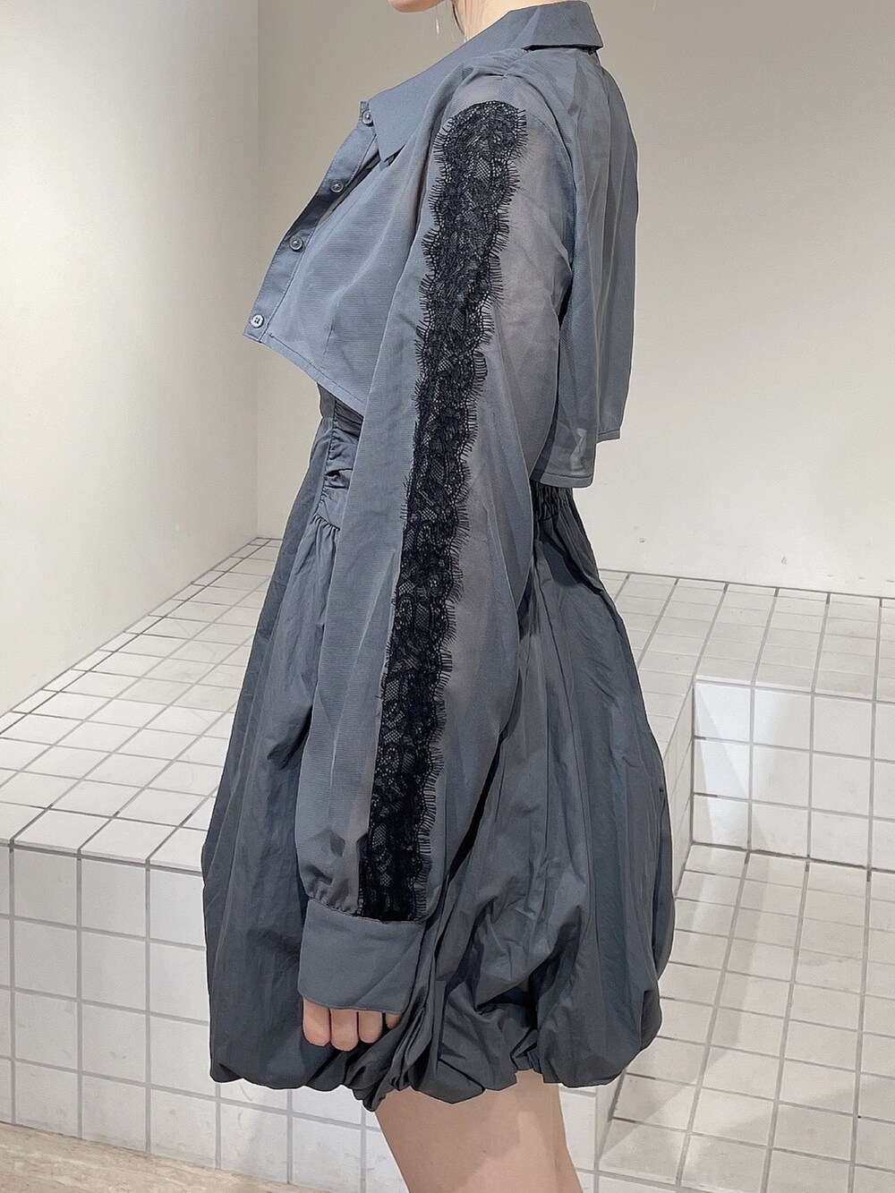 グレー系のワンピース、ブラック系のブーツ、グレー系のシュシュを着用したレディースの秋コーディネートの6枚目の写真