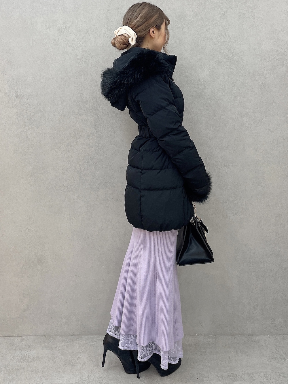 ブラック系のダウンジャケット/コート、パープル系のワンピース、ブラック系のハンドバッグを着用したレディースの秋コーディネートの2枚目の写真