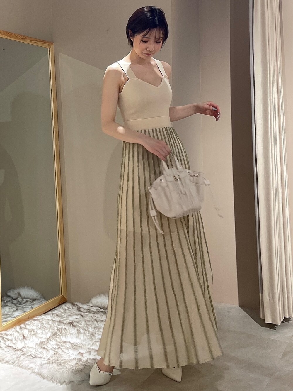 ホワイト系のワンピース、ブラック系のデニムジャケットを着用したレディースの春コーディネートの4枚目の写真