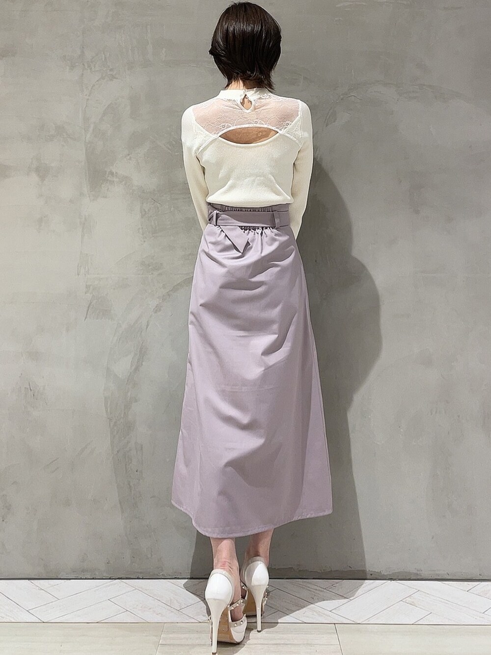 ホワイト系のニット/セーター、パープル系のスカート、ホワイト系のハンドバッグを着用したレディースの冬コーディネートの4枚目の写真