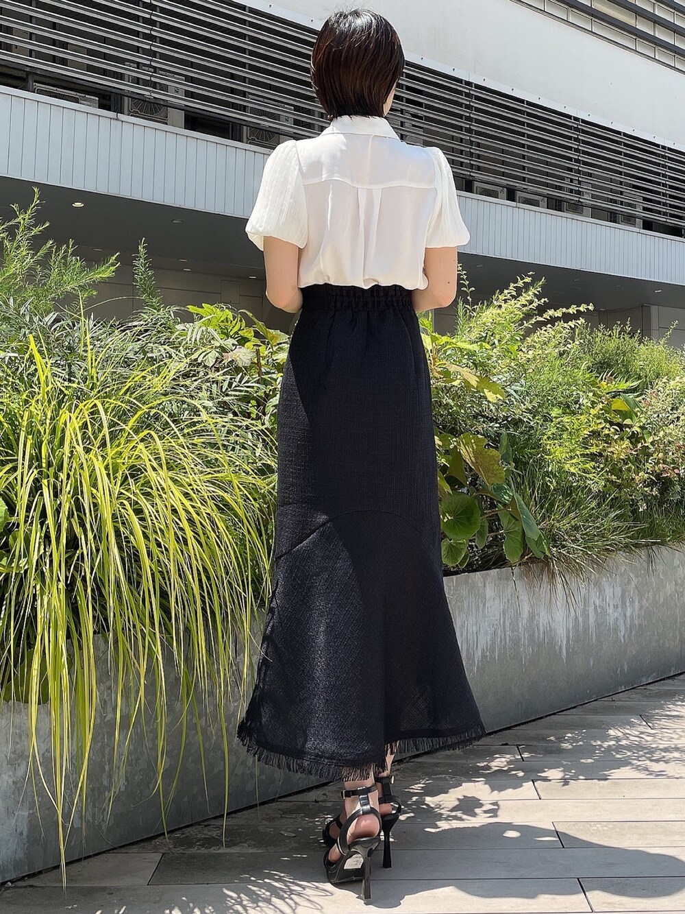 ブラック系のスカート、ホワイト系のシャツ/ブラウス、ブラック系のサンダルを着用したレディースの夏コーディネートの4枚目の写真