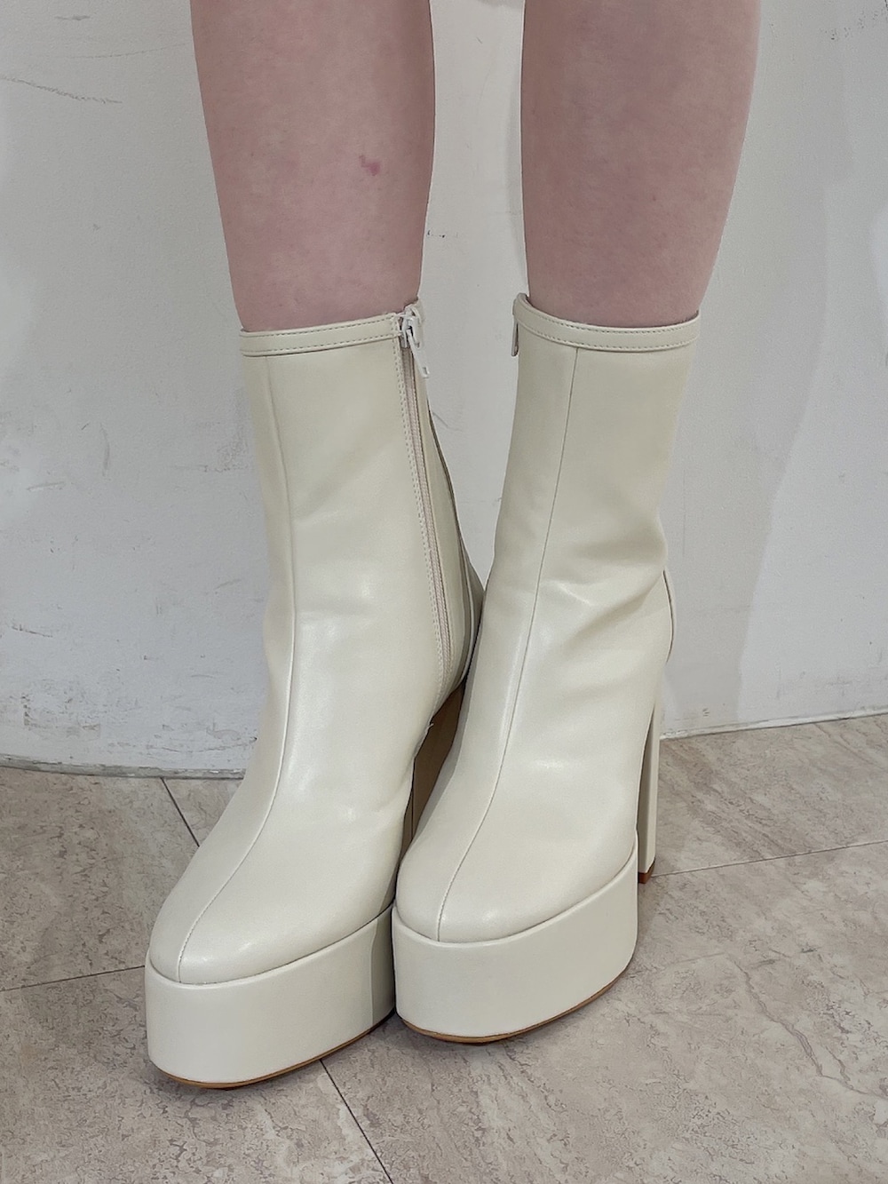 ホワイト系のニット/セーター、ホワイト系のスカート、ホワイト系のブーツを着用したレディースの冬コーディネートの7枚目の写真