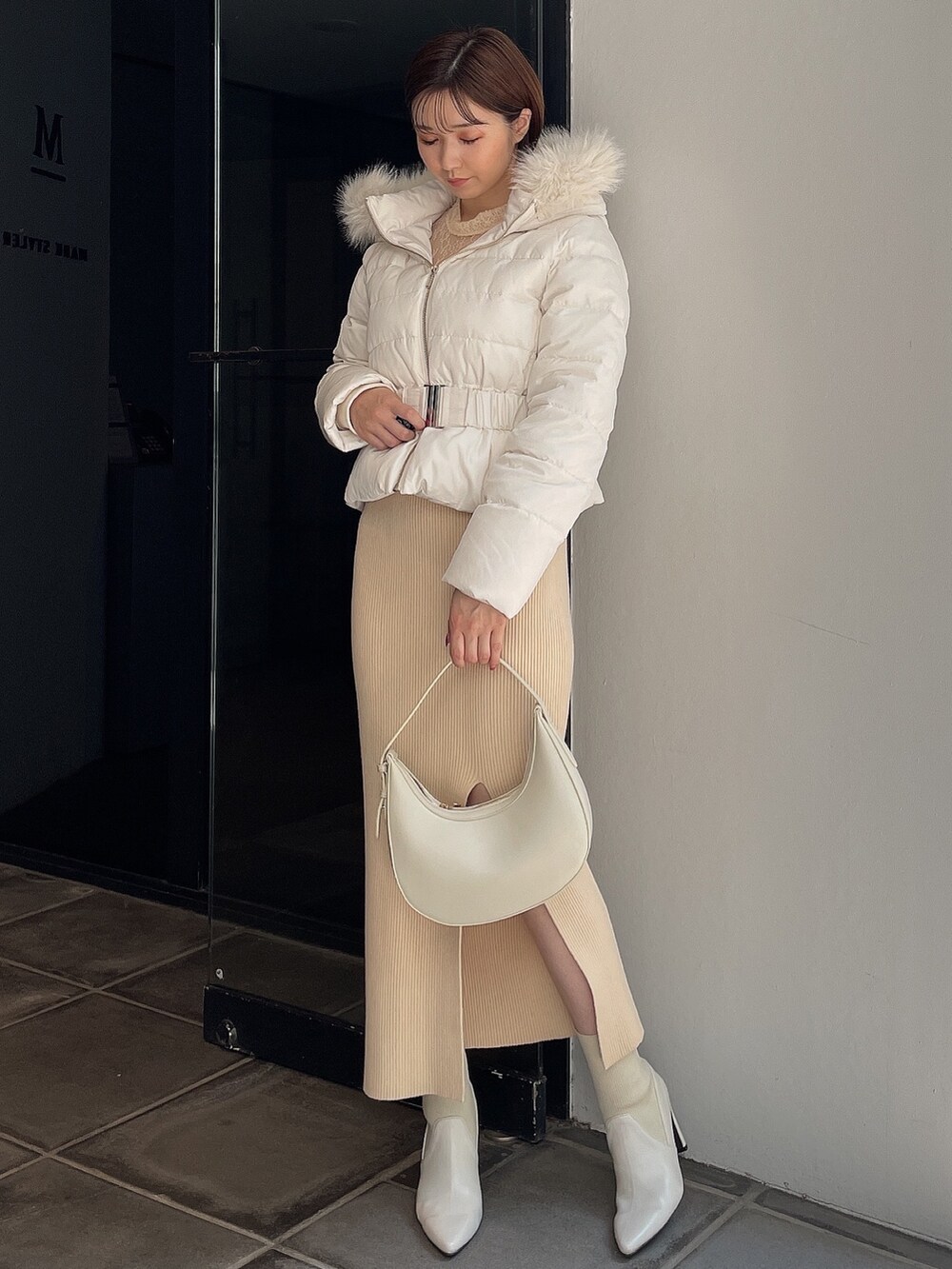 ホワイト系のダウンジャケット/コート、ホワイト系のワンピース、ホワイト系のブーツを着用したレディースの秋コーディネートの2枚目の写真