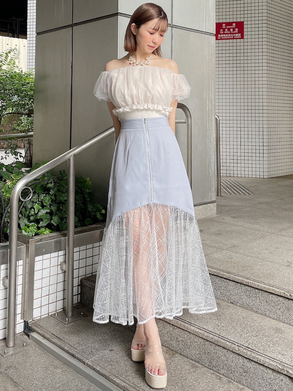 ホワイト系のシャツ/ブラウス、ブルー系のスカート、ホワイト系のサンダルを着用したレディースの夏コーディネートの3枚目の写真