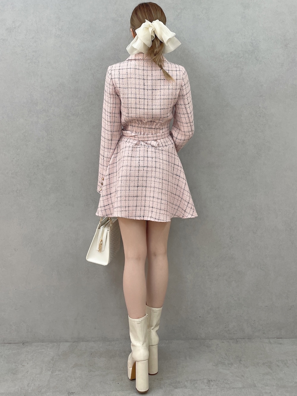 ピンク系のワンピース、ホワイト系のハンドバッグ、ホワイト系のブーツを着用したレディースの春コーディネートの4枚目の写真