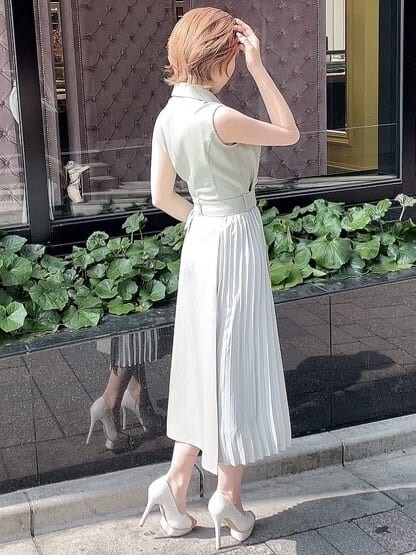 ホワイト系のパンプス、グリーン系のワンピース、ゴールド系のネックレスを着用したレディースの春コーディネートの3枚目の写真