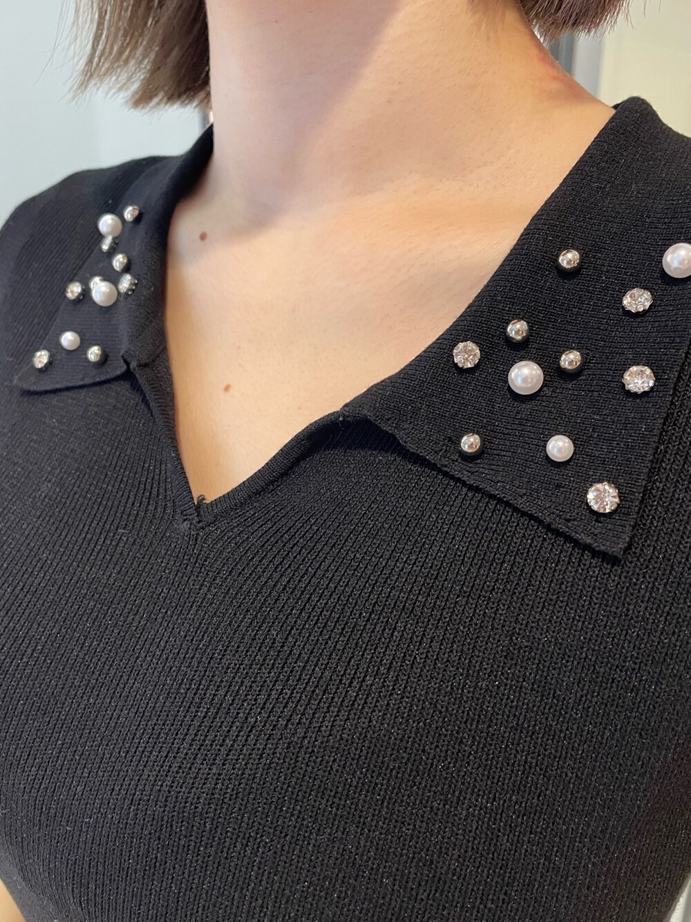 ブラック系のニット/セーター、ホワイト系のハンドバッグ、ブラック系のサンダルを着用したレディースの春コーディネートの8枚目の写真