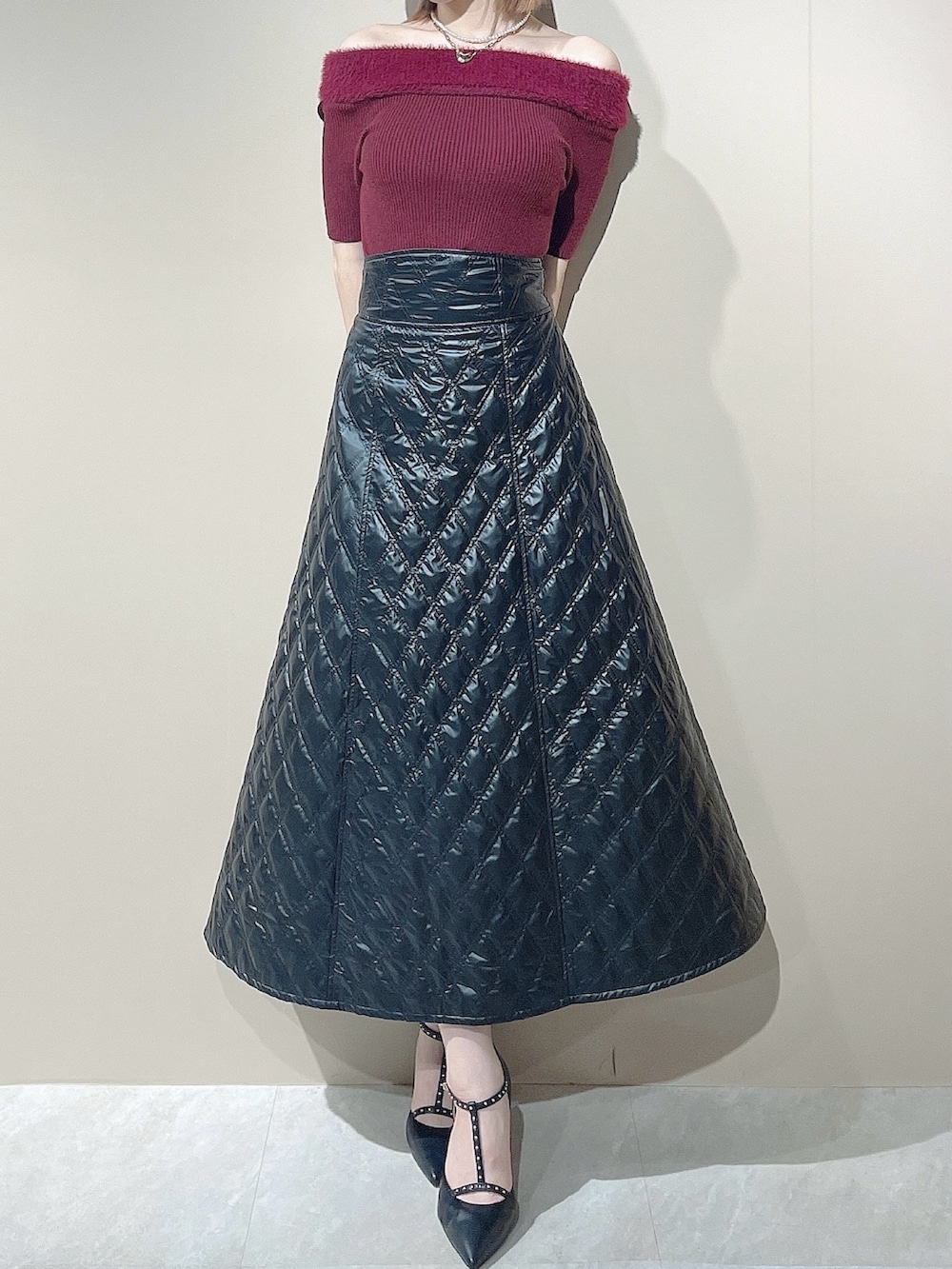 ブラック系のパンプス、レッド系のニット/セーター、ブラック系のスカートを着用したレディースの夏コーディネートの3枚目の写真