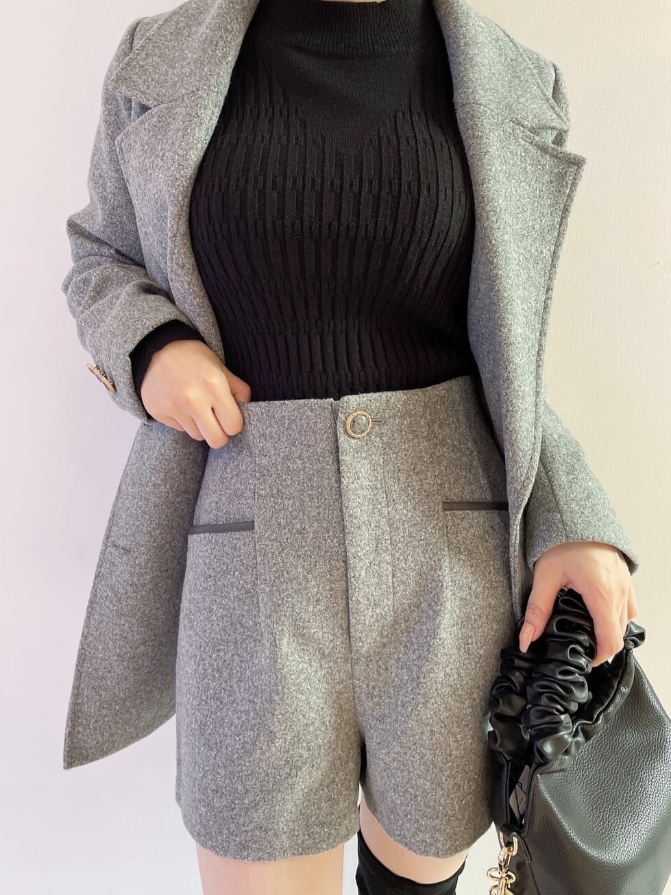 ブラック系のブーツ、グレー系のその他パンツ、ブラック系のハンドバッグを着用したレディースの秋コーディネートの6枚目の写真