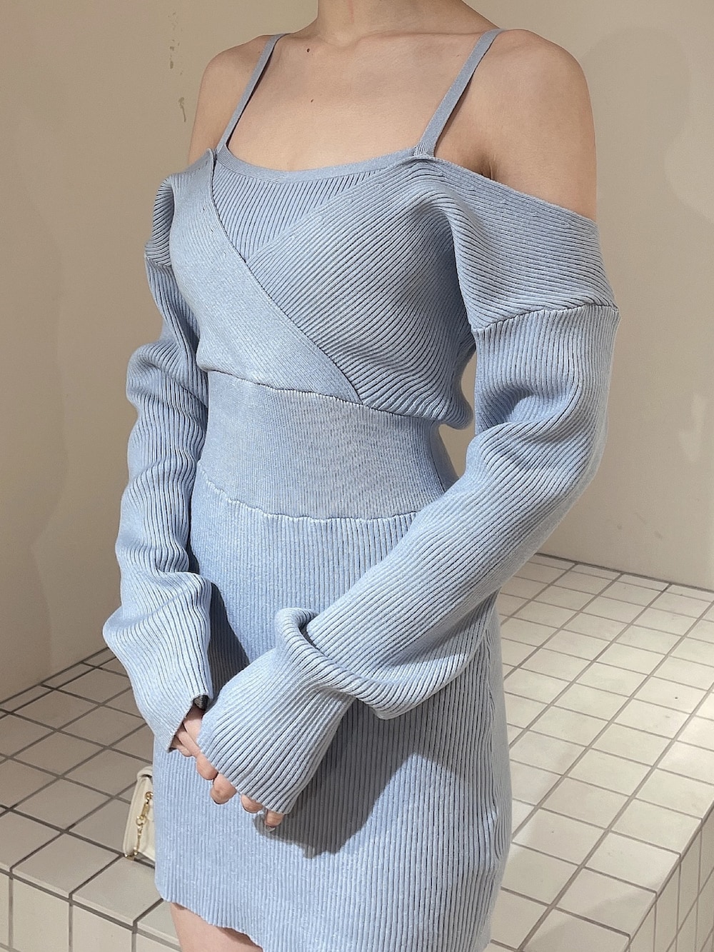 ブルー系のワンピース、ホワイト系のショルダーバッグ、ホワイト系のブーツを着用したレディースの冬コーディネートの5枚目の写真