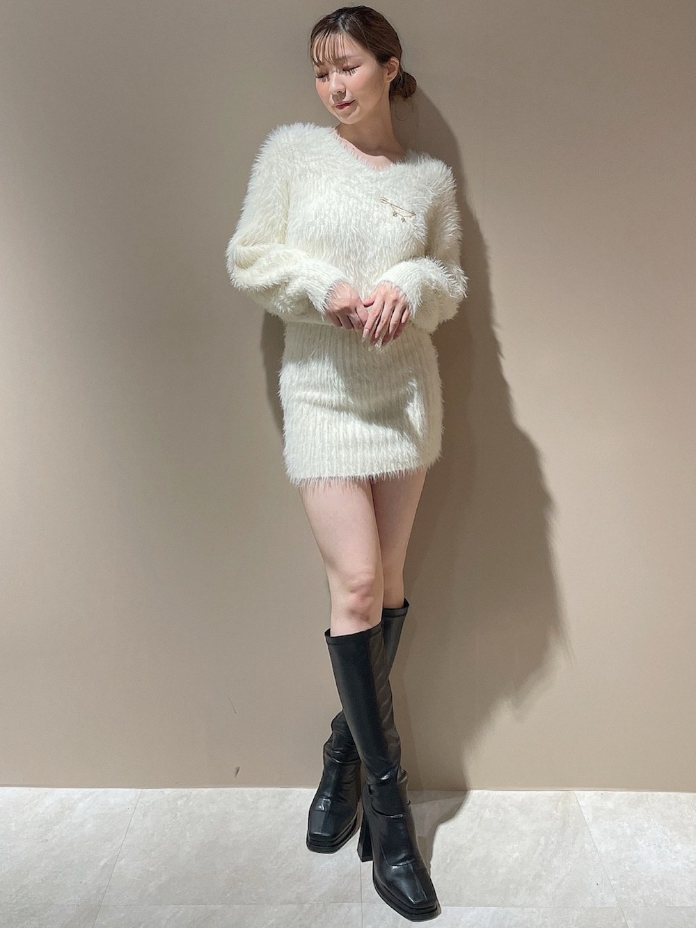 ホワイト系のワンピース、ブラック系のブーツを着用したレディースの秋コーディネートの3枚目の写真